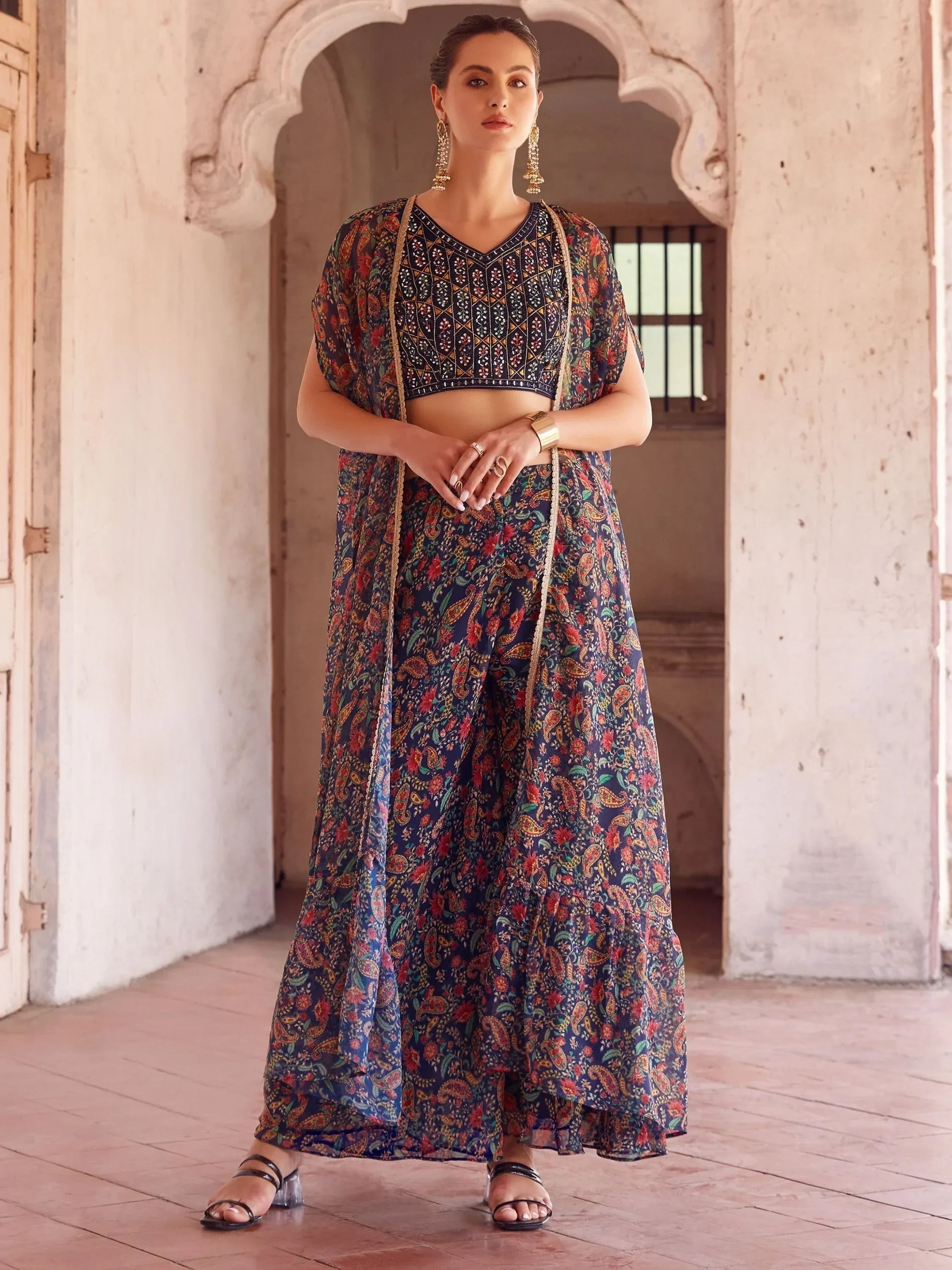 Woman in a black floral print lehenga choli set with dupatta, traditional jewelry, ethnic wear
