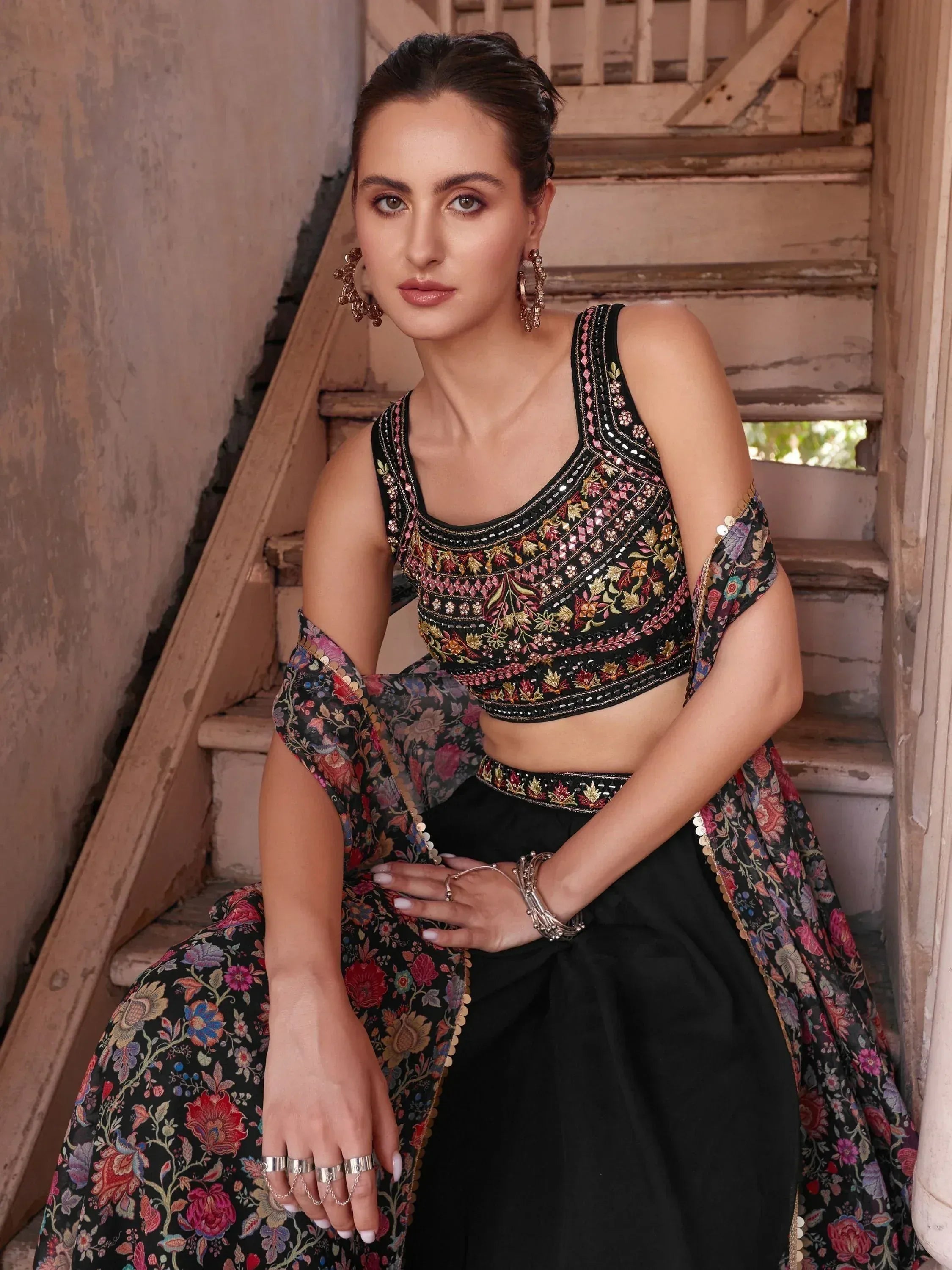 Woman in black floral embroidered lehenga choli with matching dupatta, ethnic jewelry