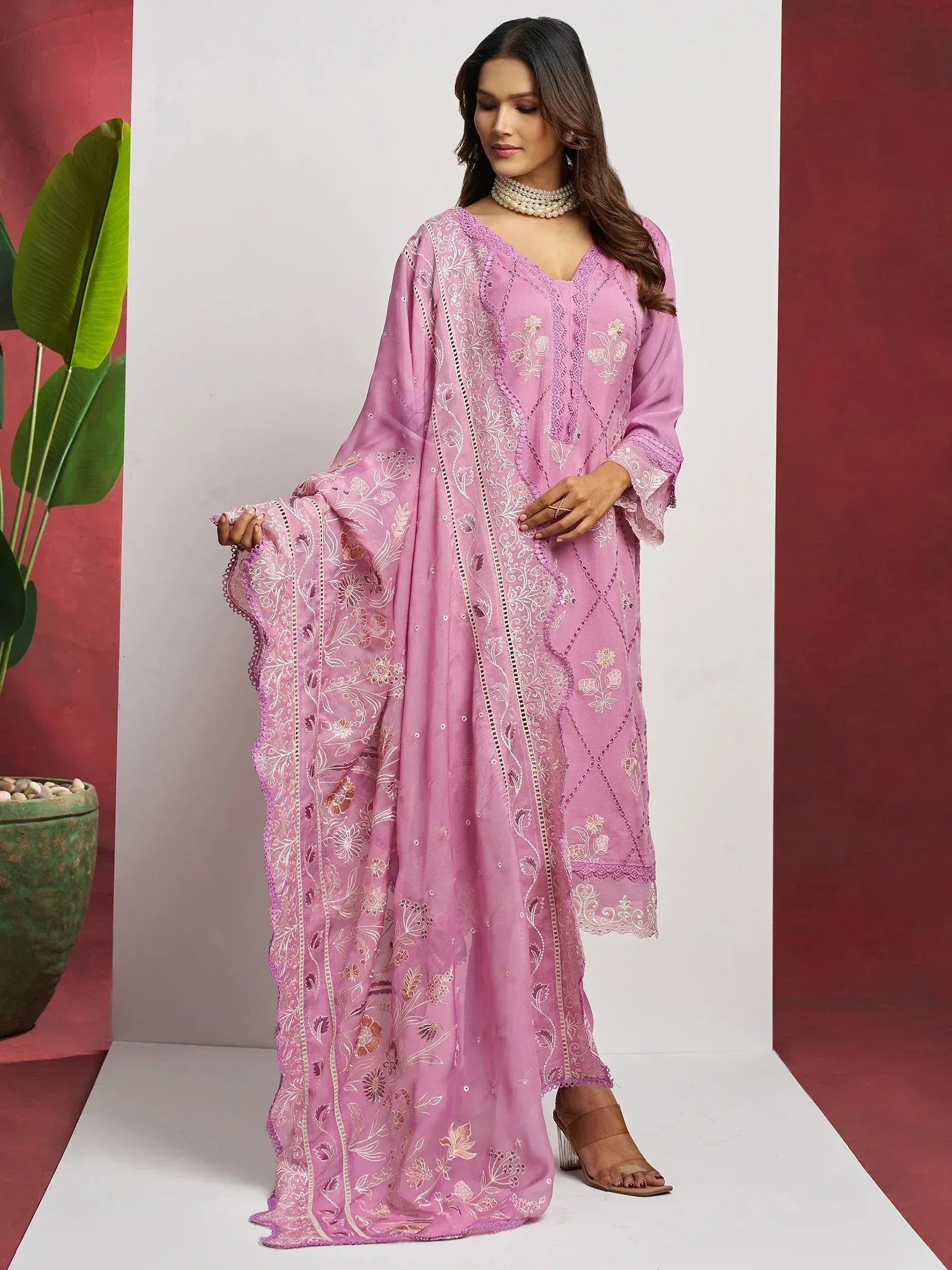 Pink embroidered salwar kameez with floral motifs and lace detailing, perfect for ethnic occasions.