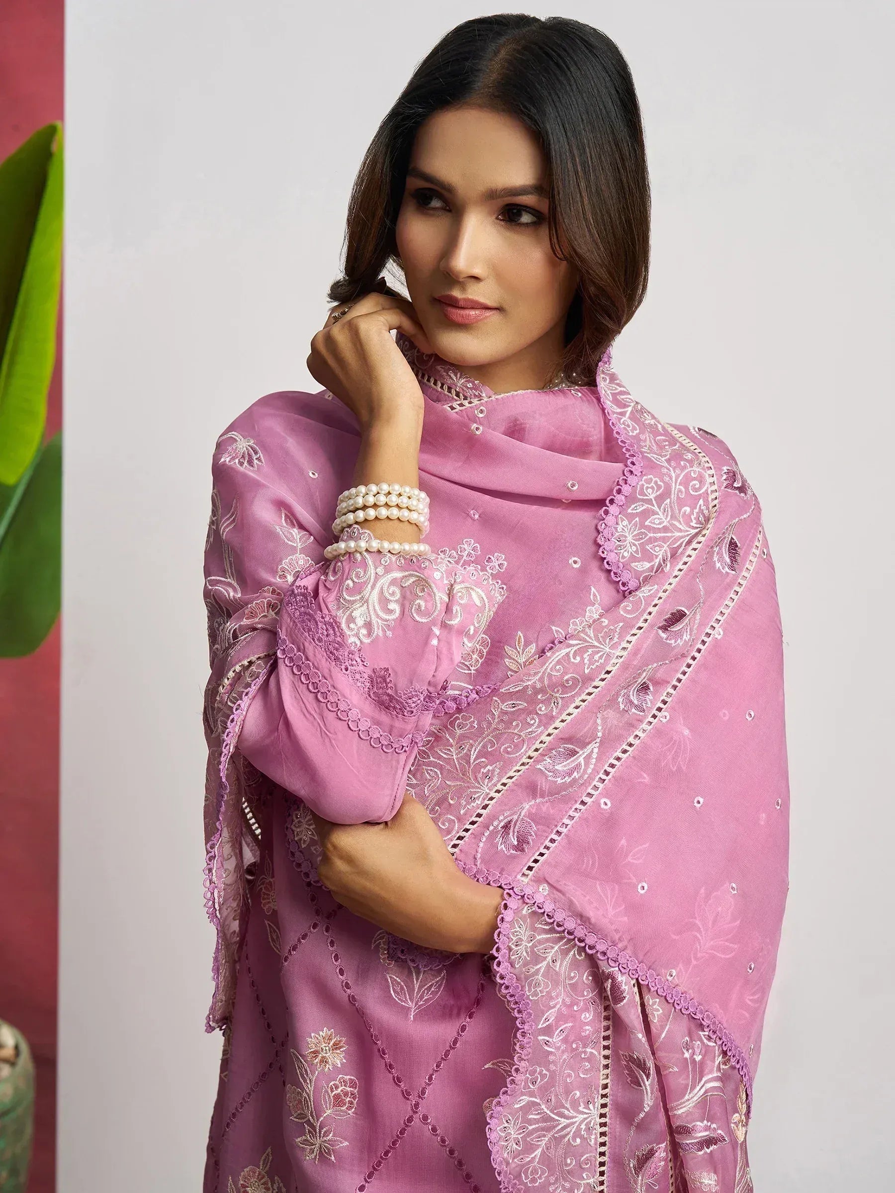 Pink embroidered salwar kameez with floral lace detailing and pearl bangles