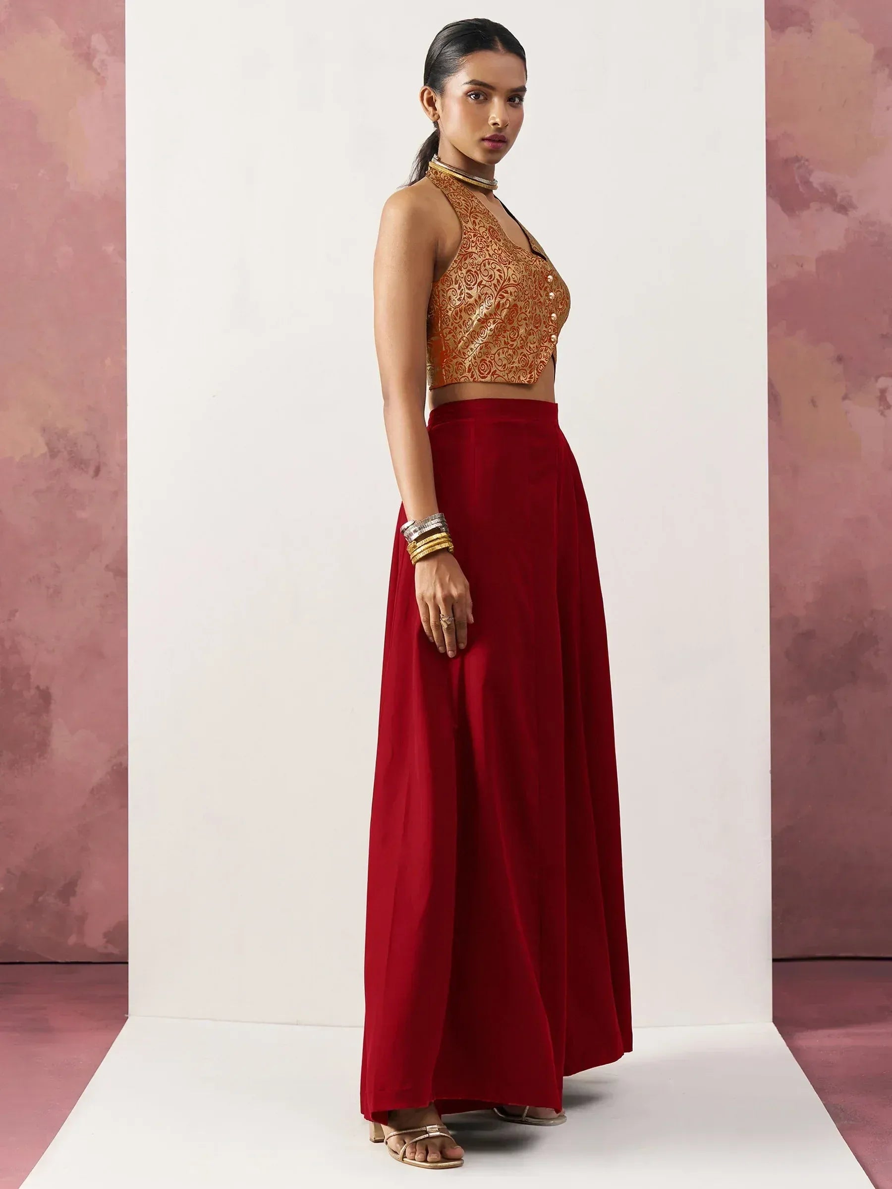 Woman in red ethnic skirt and gold embroidered crop top, Indian designer wear
