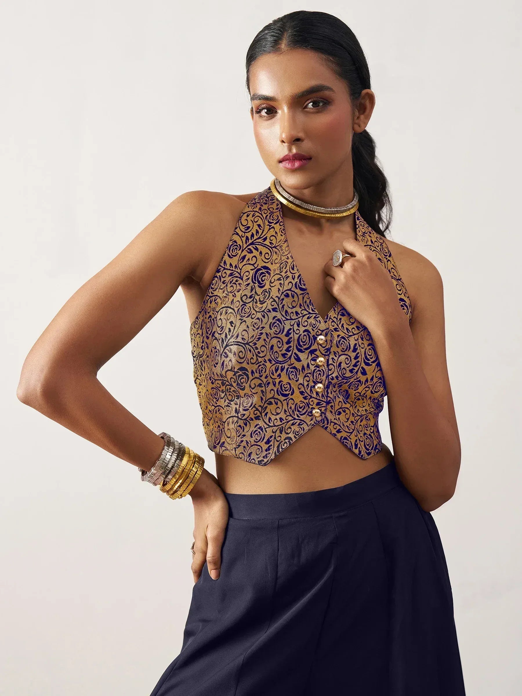Gold and blue floral halter neck crop top with gold buttons, paired with navy pants for ethnic wear