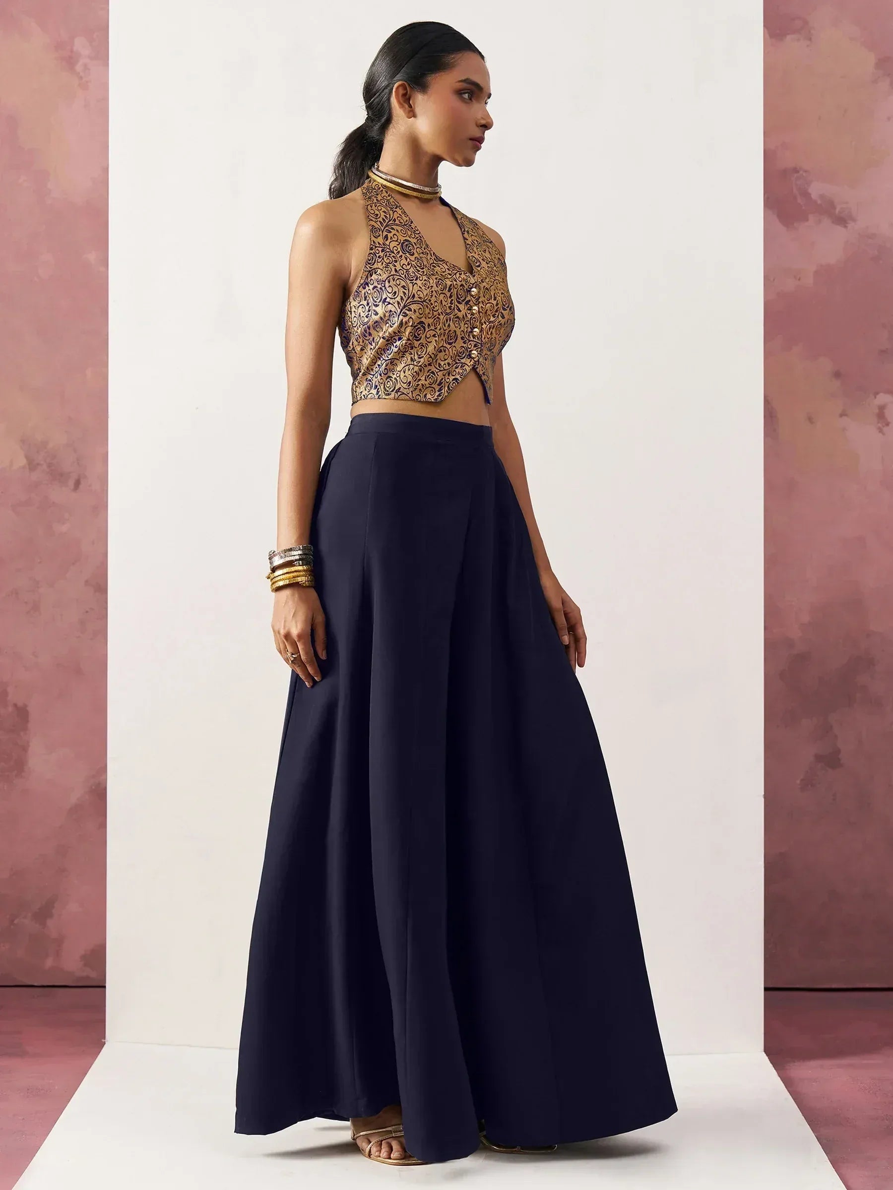 Woman in gold embroidered halter top and navy blue palazzo pants, Indian ethnic wear
