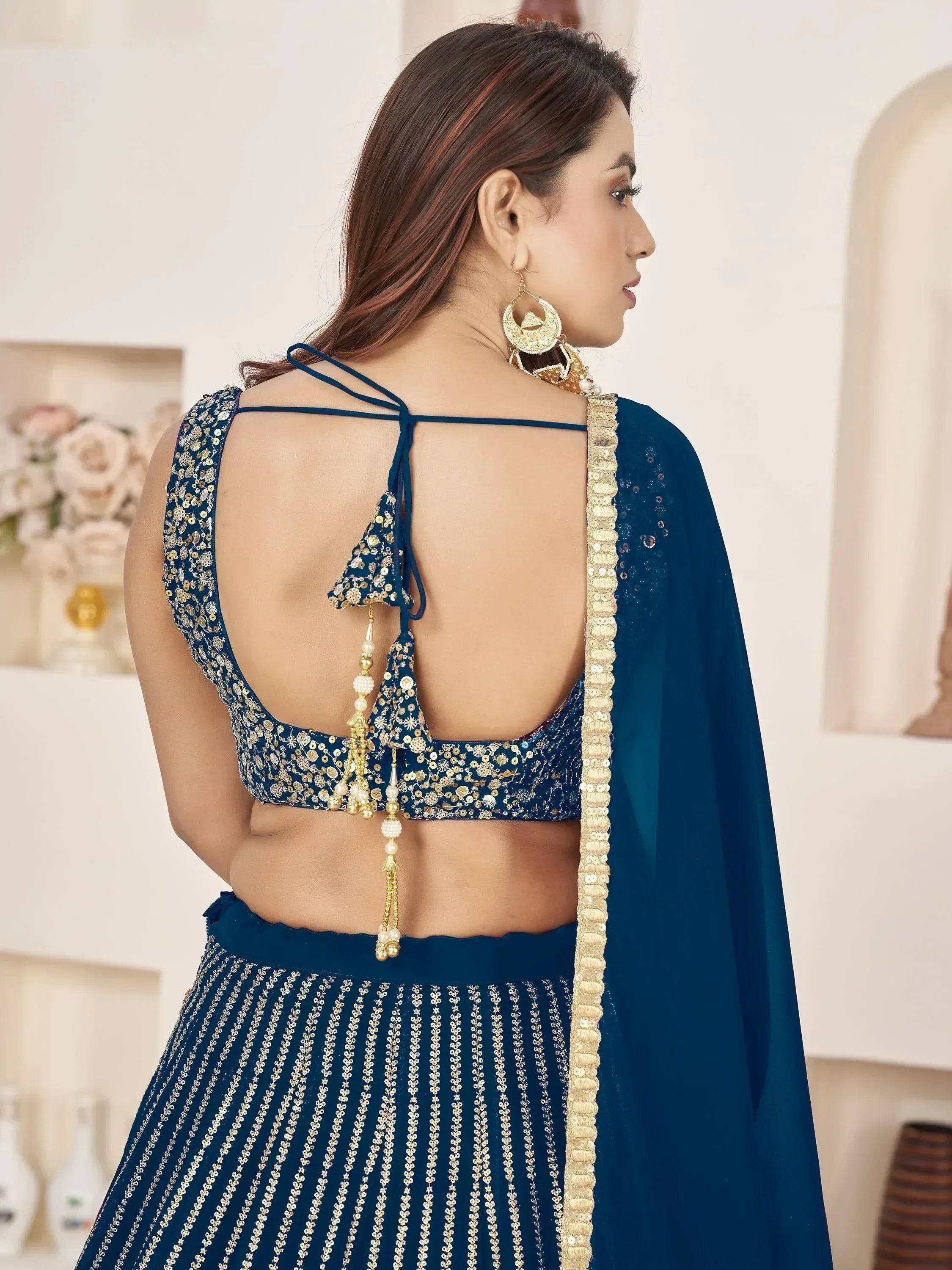 Blue designer lehenga choli with gold sequins, open back blouse, and tassel detailing for ethnic wear