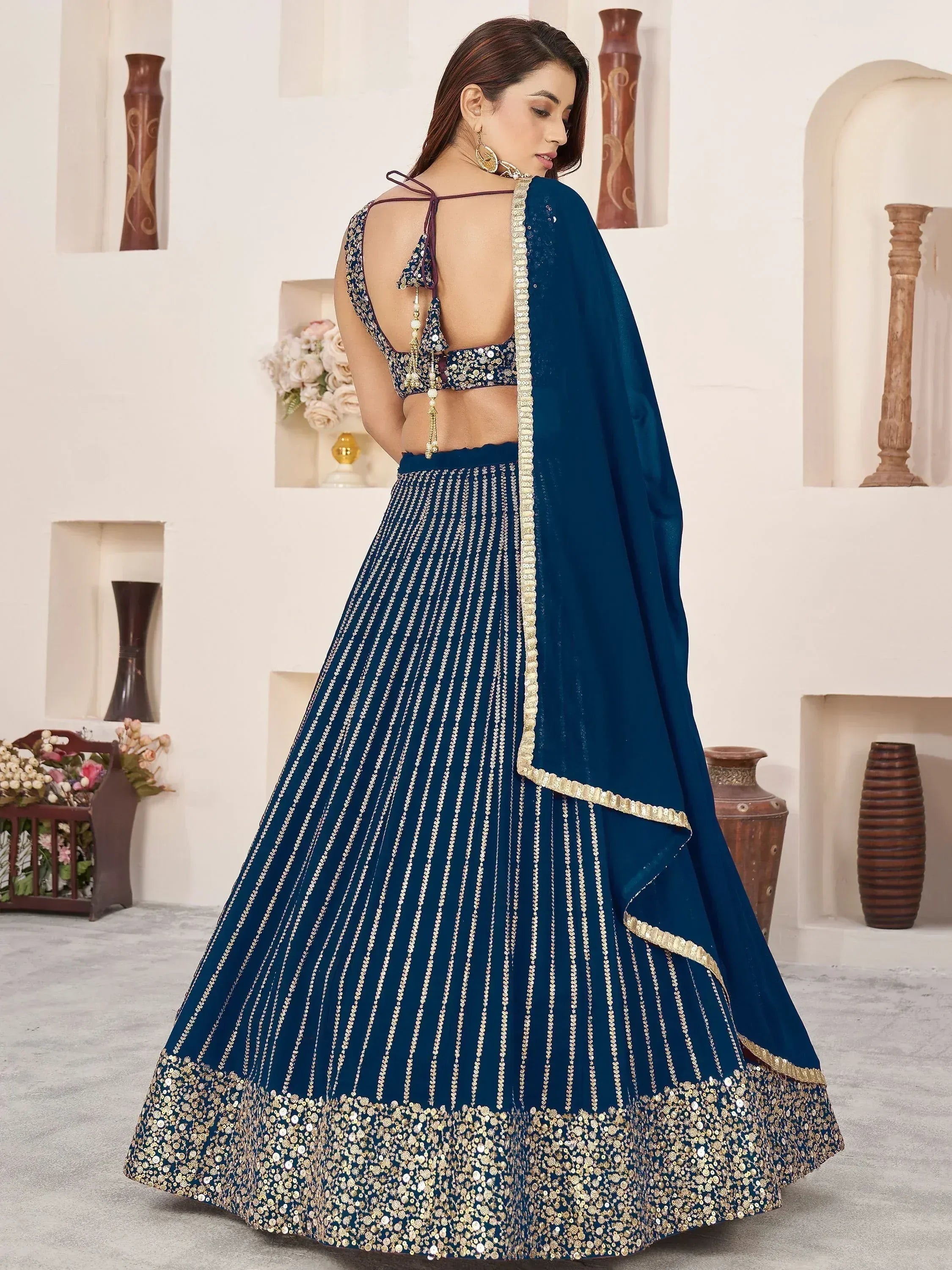Elegant navy blue lehenga choli with gold embroidery and sequin detailing, perfect for Indian ethnic wear occasions.