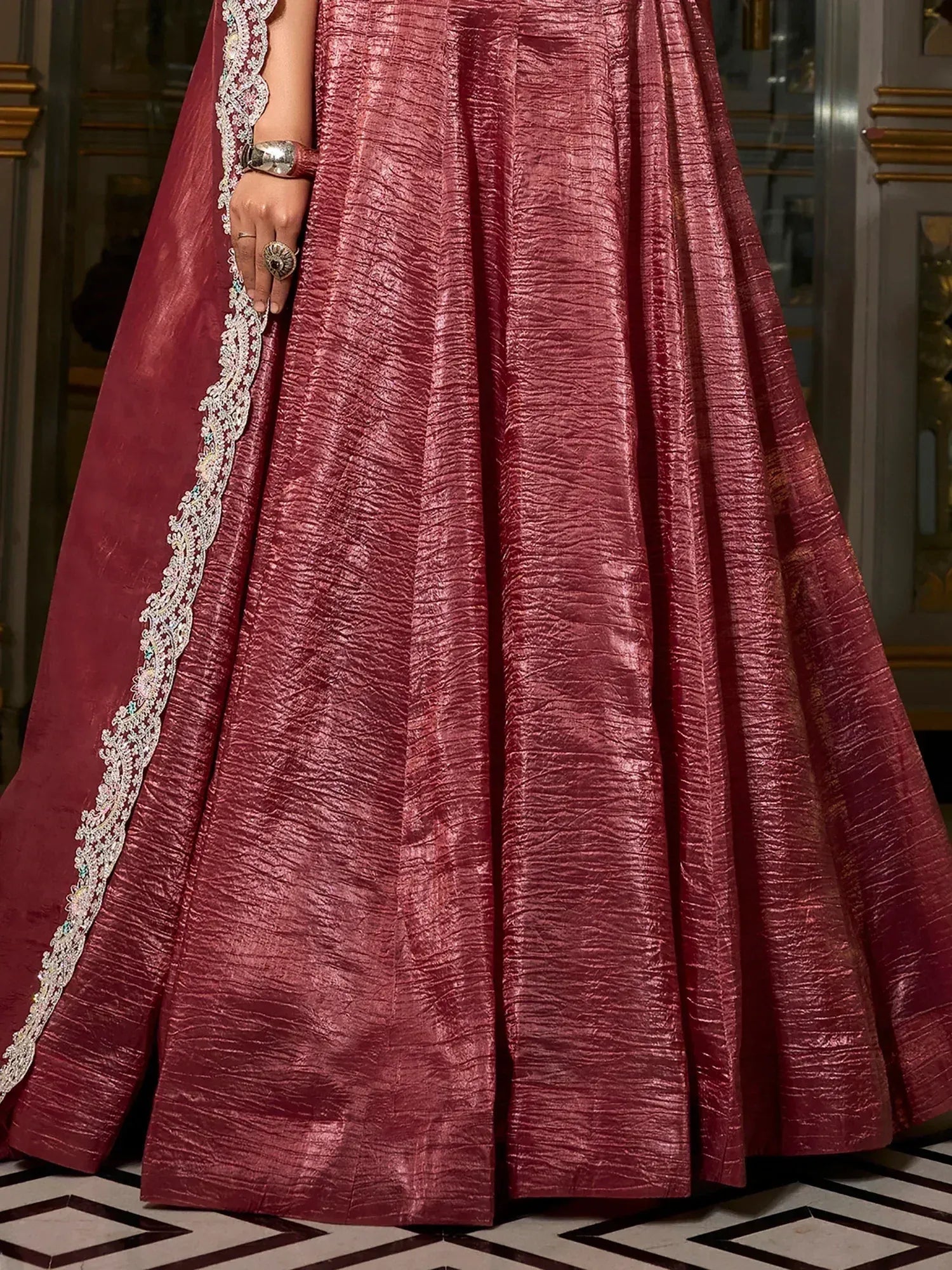 Elegant maroon lehenga with intricate lace border and shimmering fabric, perfect for Indian ethnic wear.