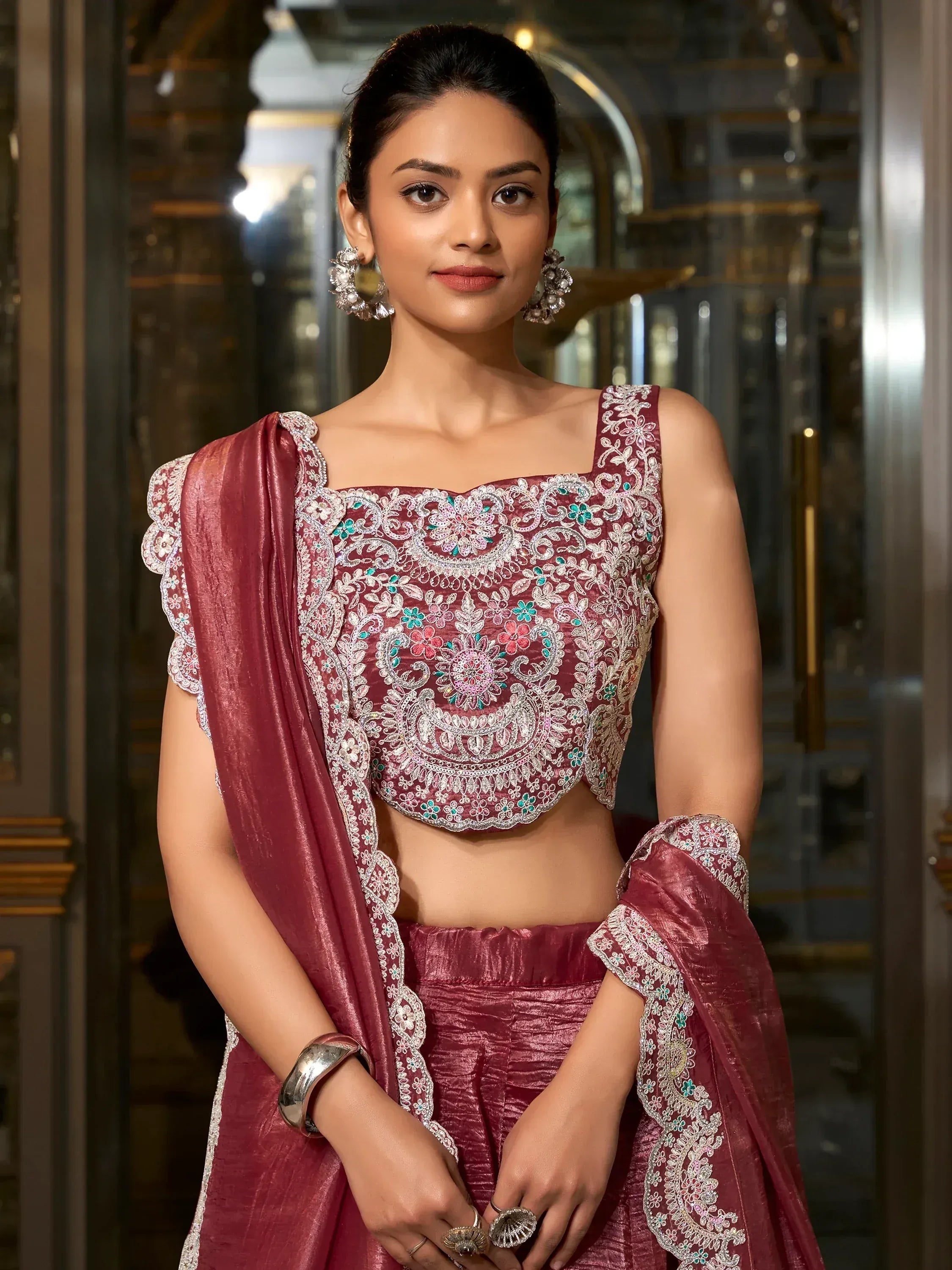 Elegant maroon lehenga choli with intricate floral embroidery and scalloped sleeves, perfect for Indian ethnic wear.