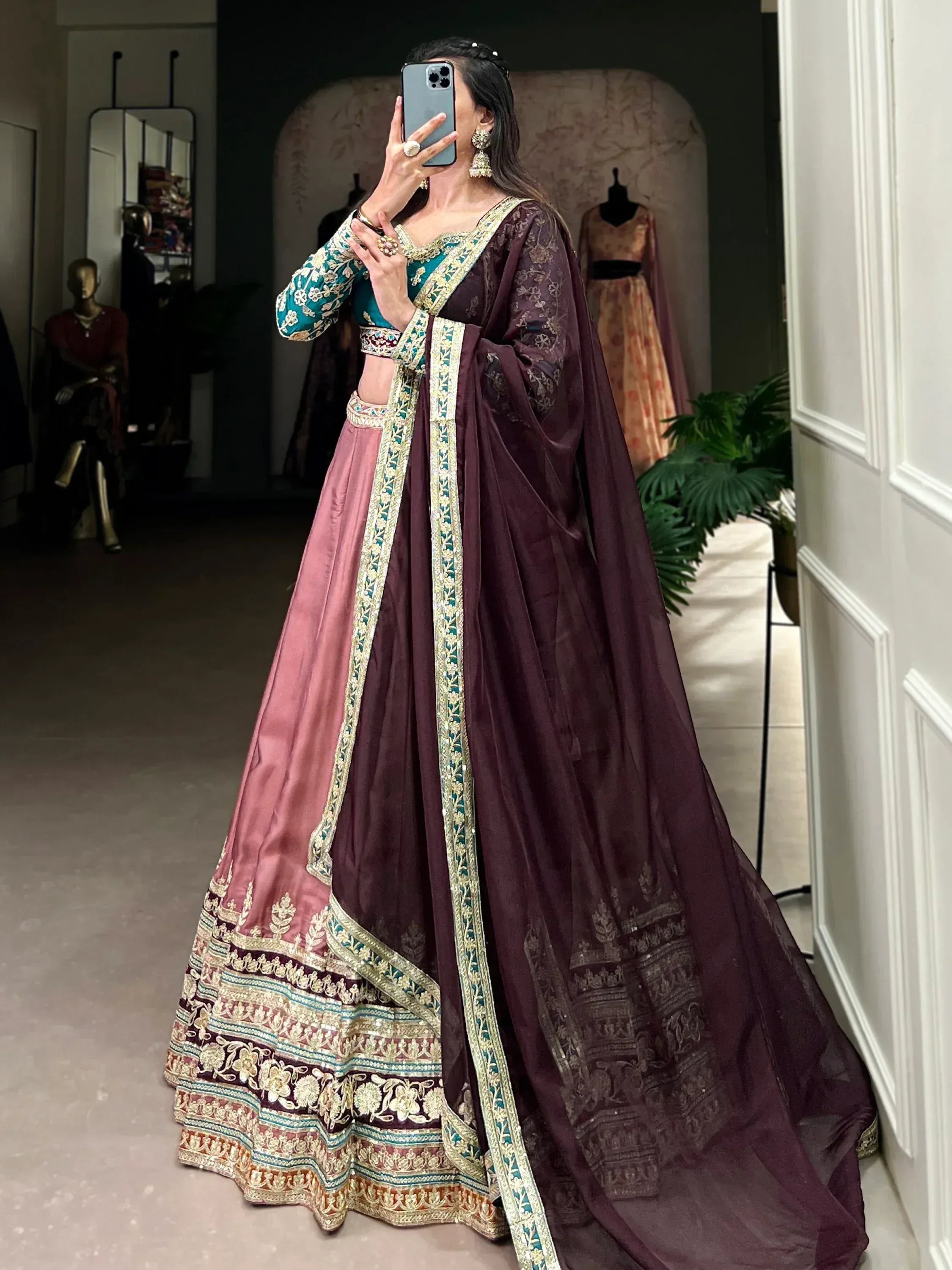 Elegant maroon and teal embroidered lehenga choli with gold detailing, perfect for Indian weddings and festive occasions.