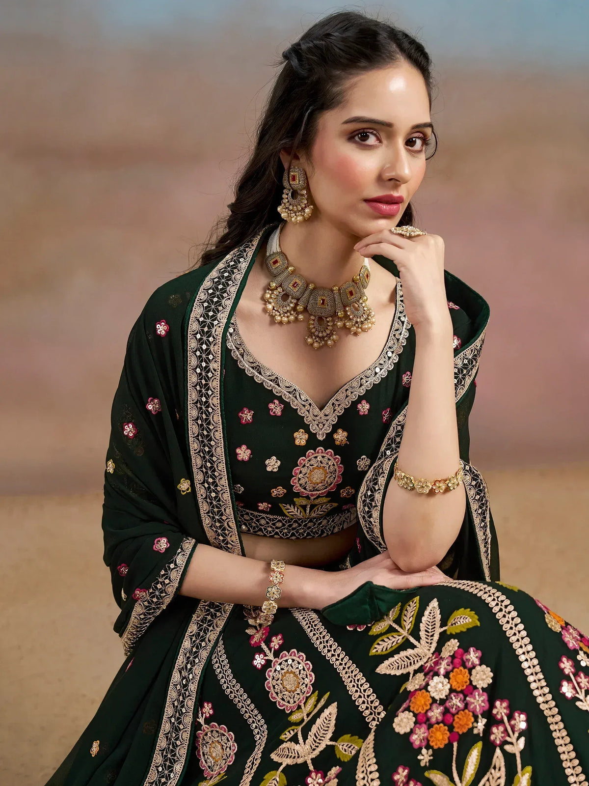 Elegant green embroidered lehenga choli with floral motifs and gold jewelry for Indian ethnic wear