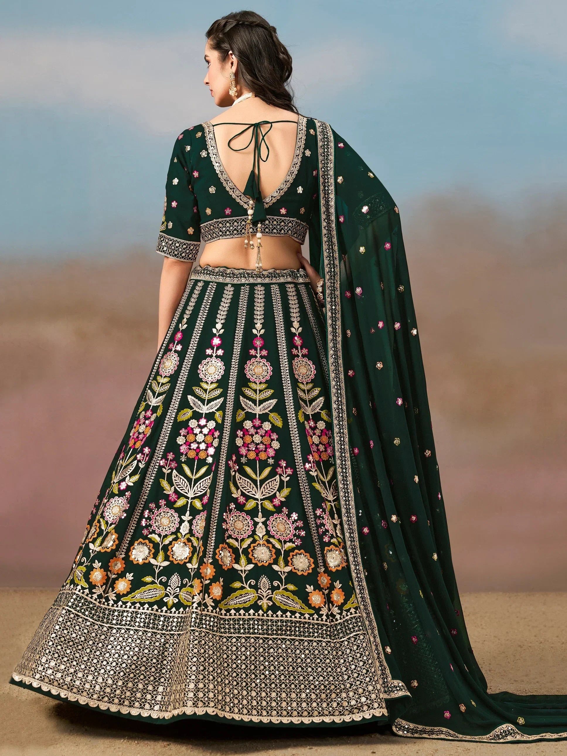 Emerald green designer lehenga choli with floral embroidery and back tie blouse, perfect for Indian weddings.