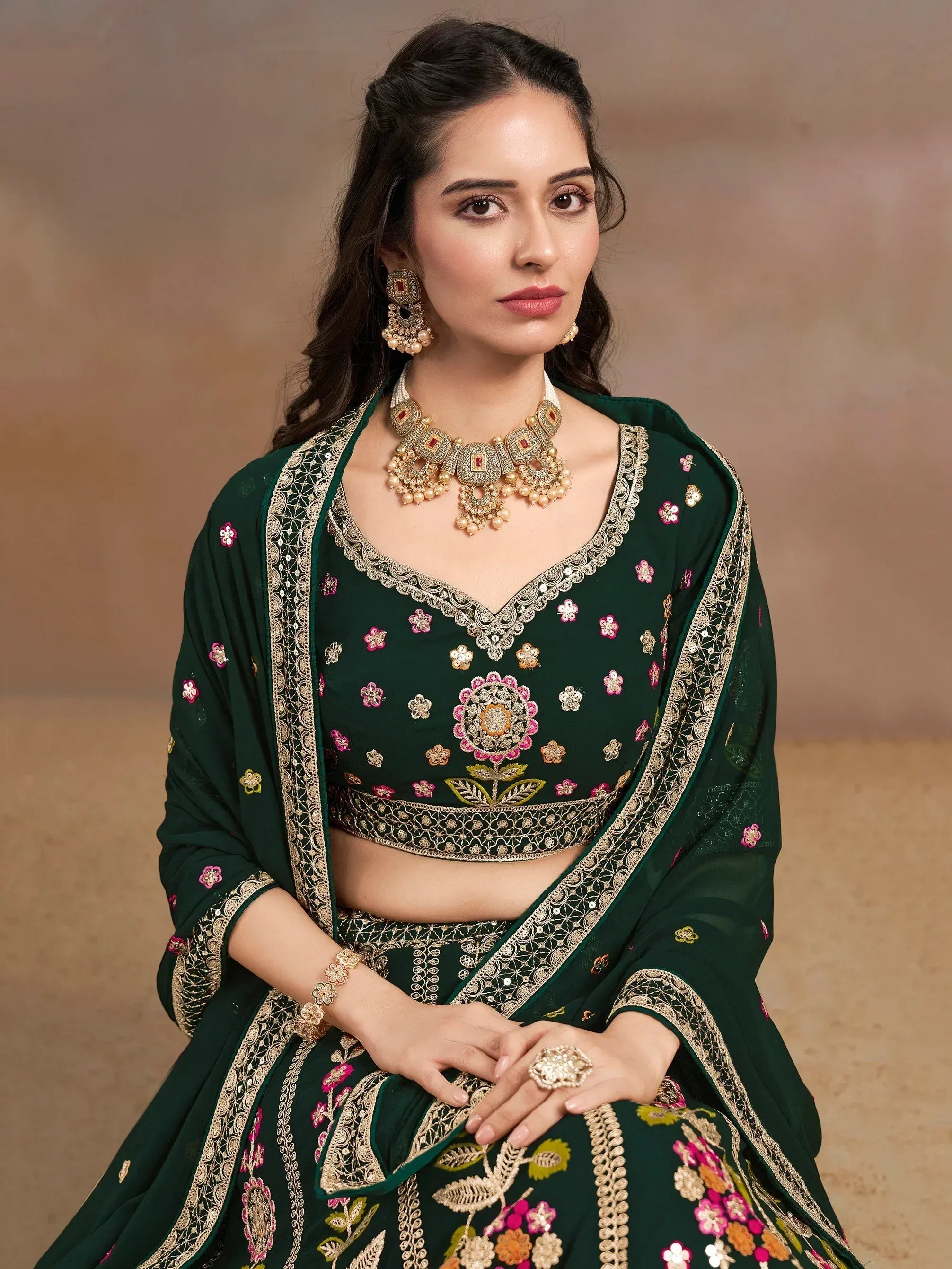 Emerald green embroidered lehenga choli with floral motifs and gold detailing, perfect for Indian ethnic wear.