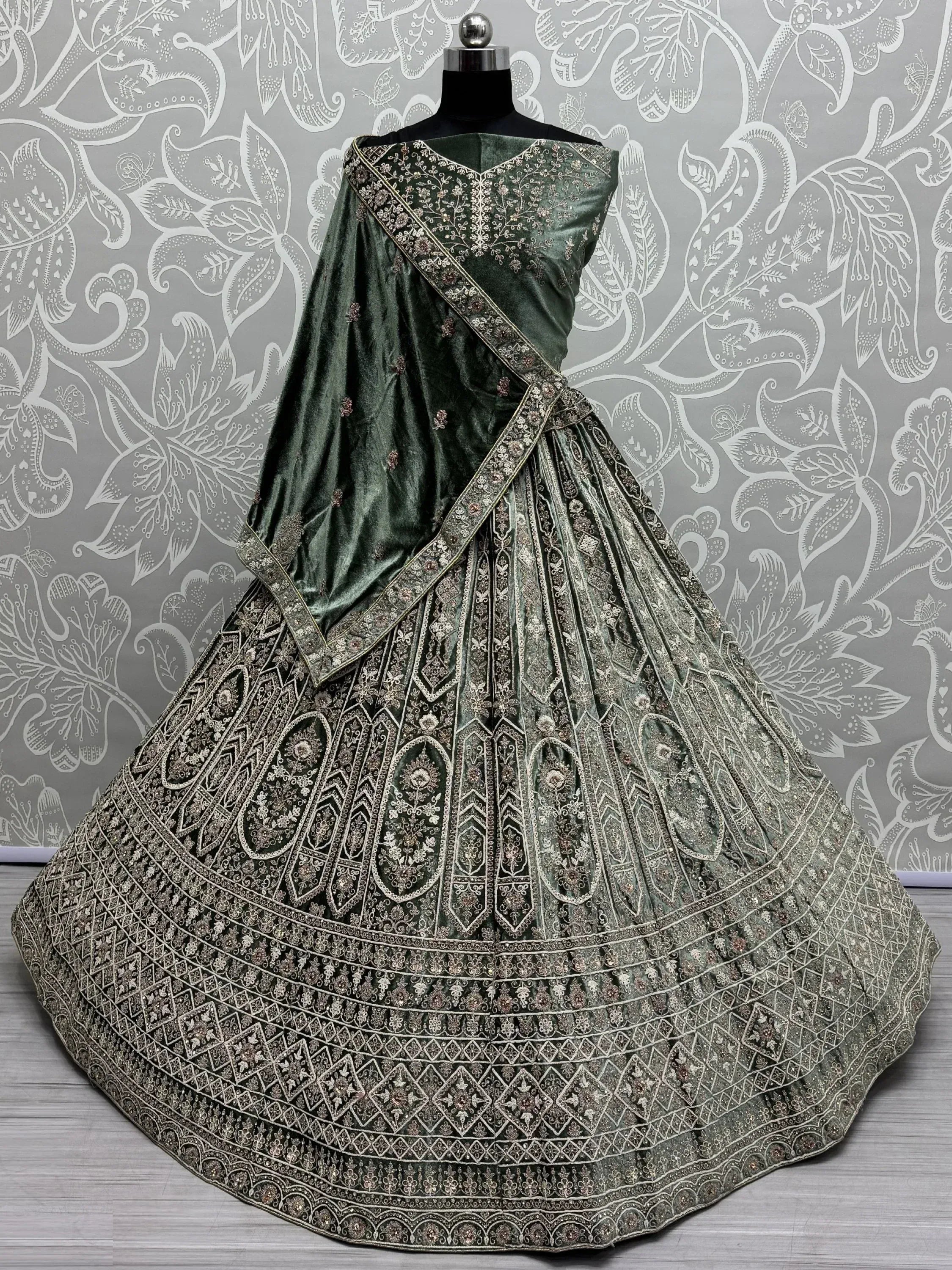 Emerald green velvet lehenga choli with intricate gold embroidery, perfect for Indian weddings and festive occasions.