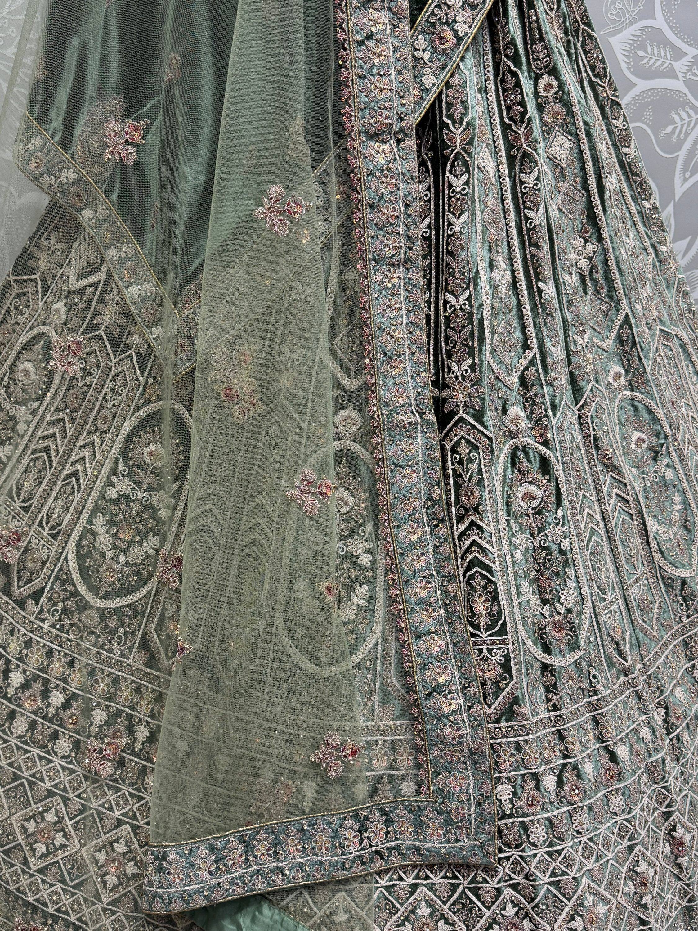Emerald green velvet lehenga choli with intricate floral embroidery and sheer dupatta for Indian ethnic wear