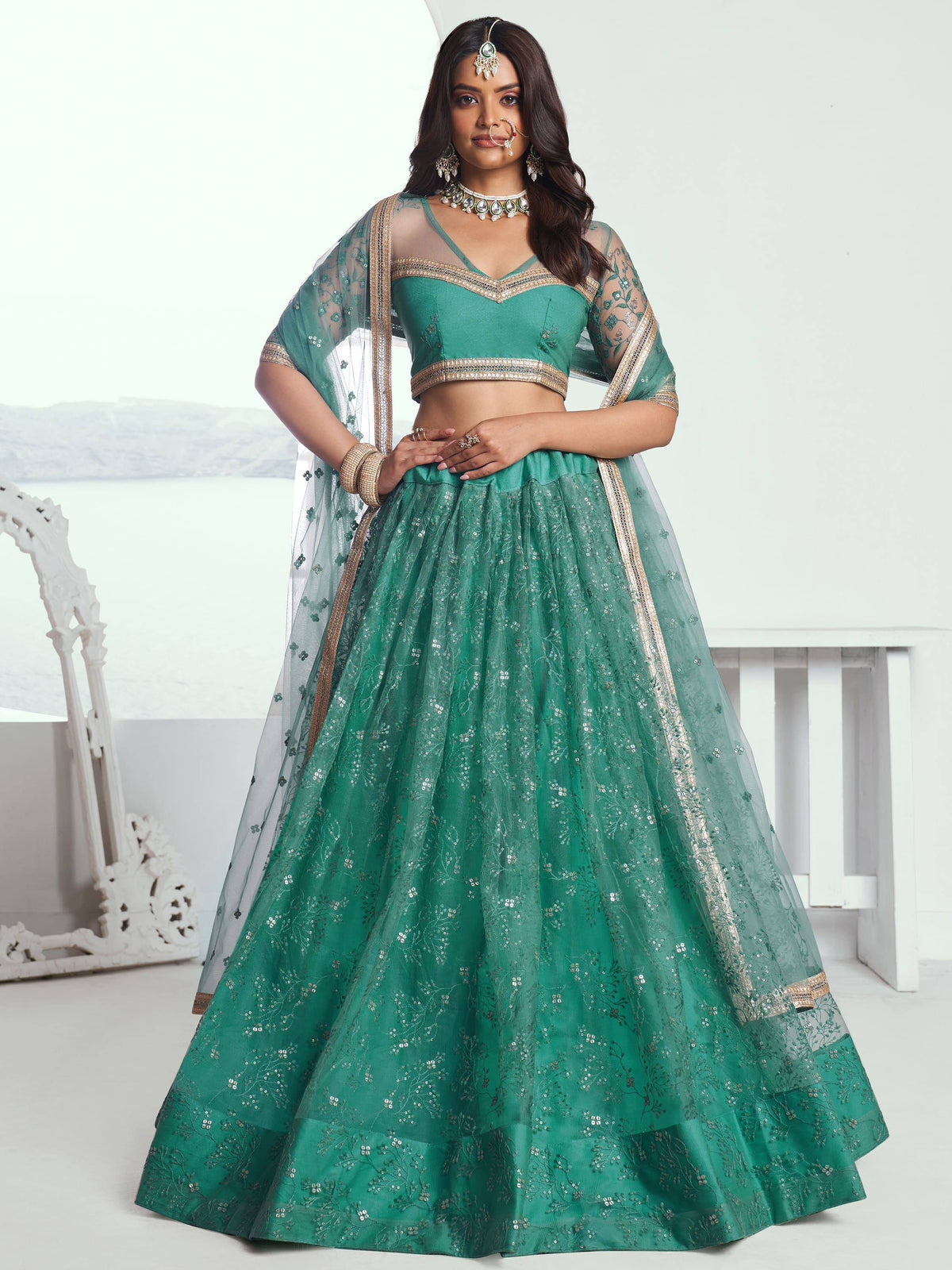 Emerald green designer lehenga choli with gold embroidery and sheer dupatta, perfect for Indian weddings and festive occasions.