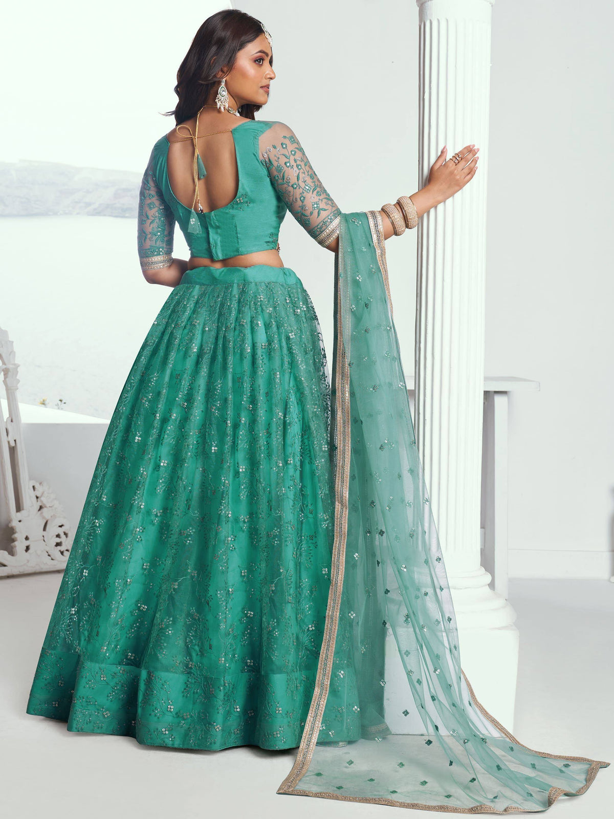 Emerald green designer lehenga choli with sheer sleeves, floral embroidery, and sequin detailing for Indian ethnic wear