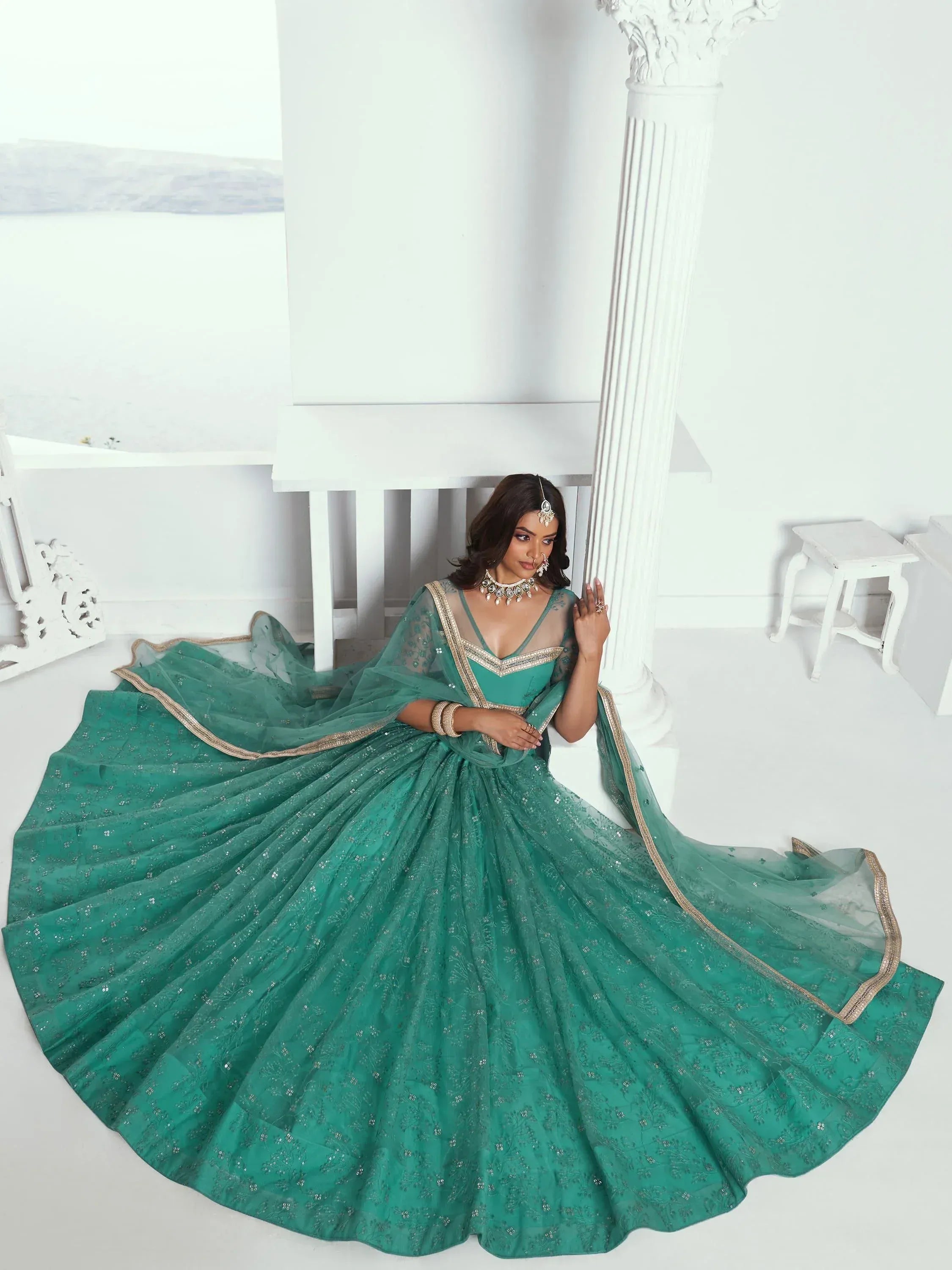 Emerald green designer lehenga choli with gold embroidery, perfect for weddings and festive occasions.