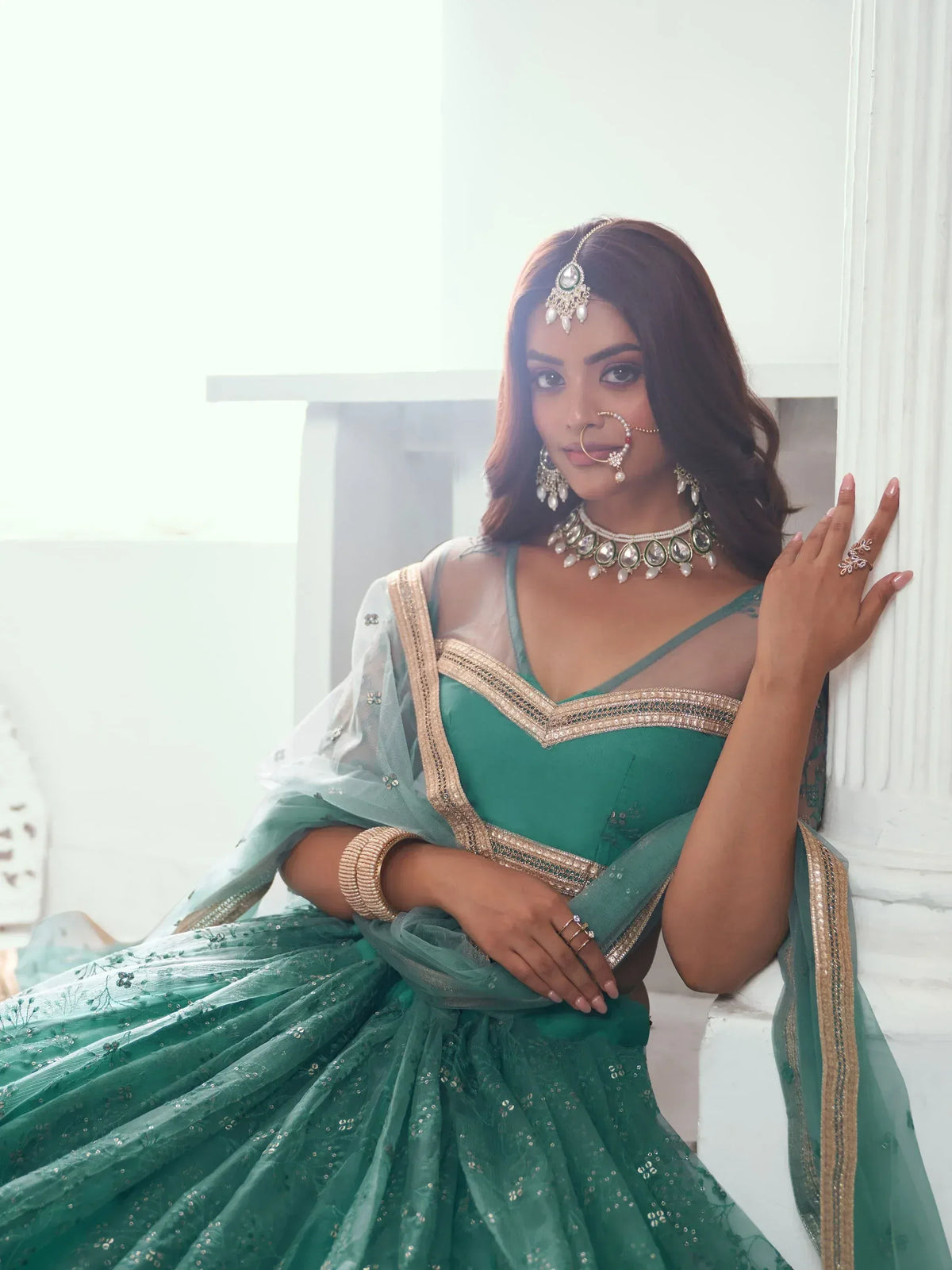 Emerald green designer lehenga choli with gold embroidery and traditional jewelry for Indian ethnic wear