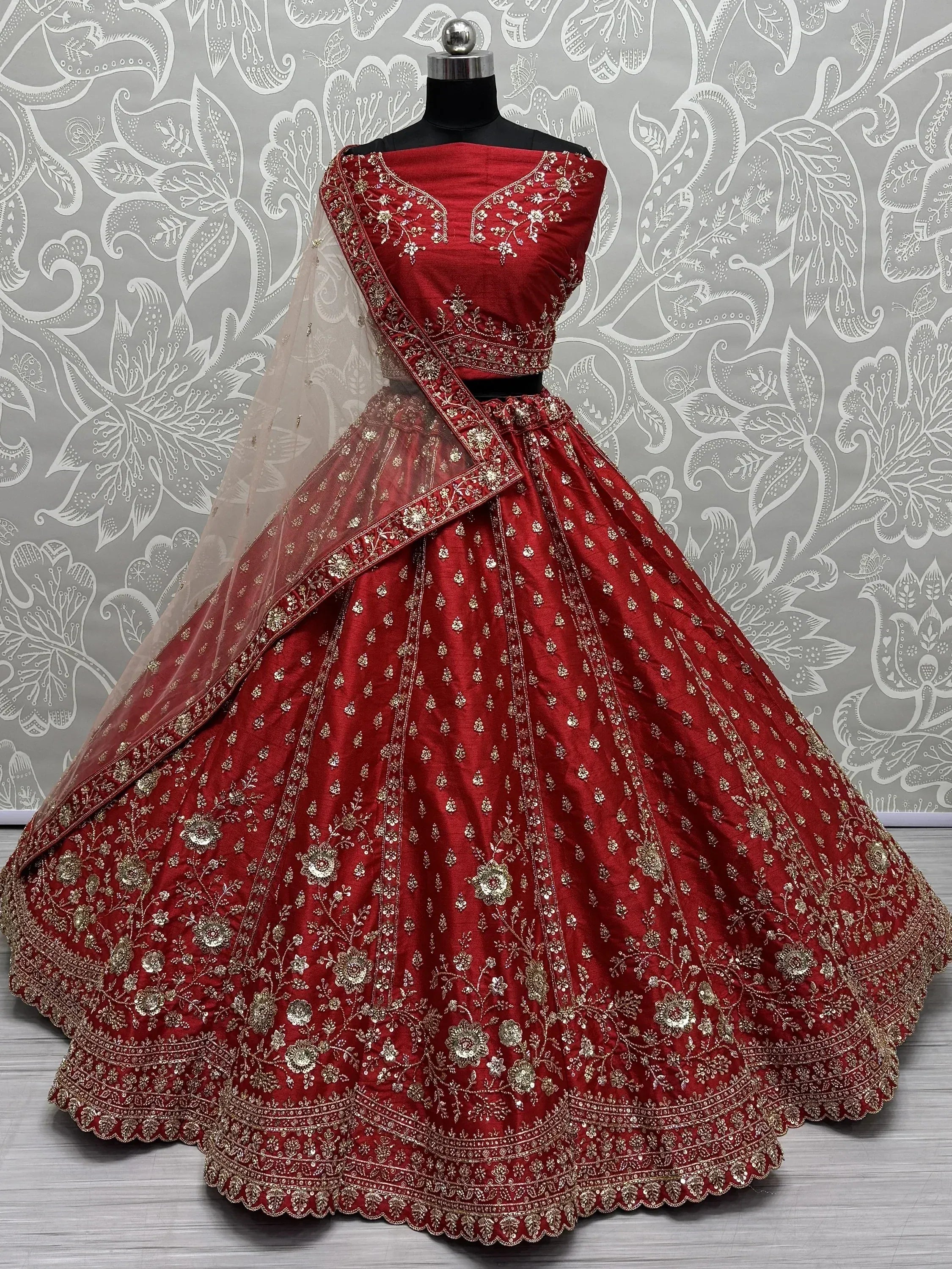 Red designer lehenga choli with gold embroidery, perfect for Indian weddings and festive occasions.