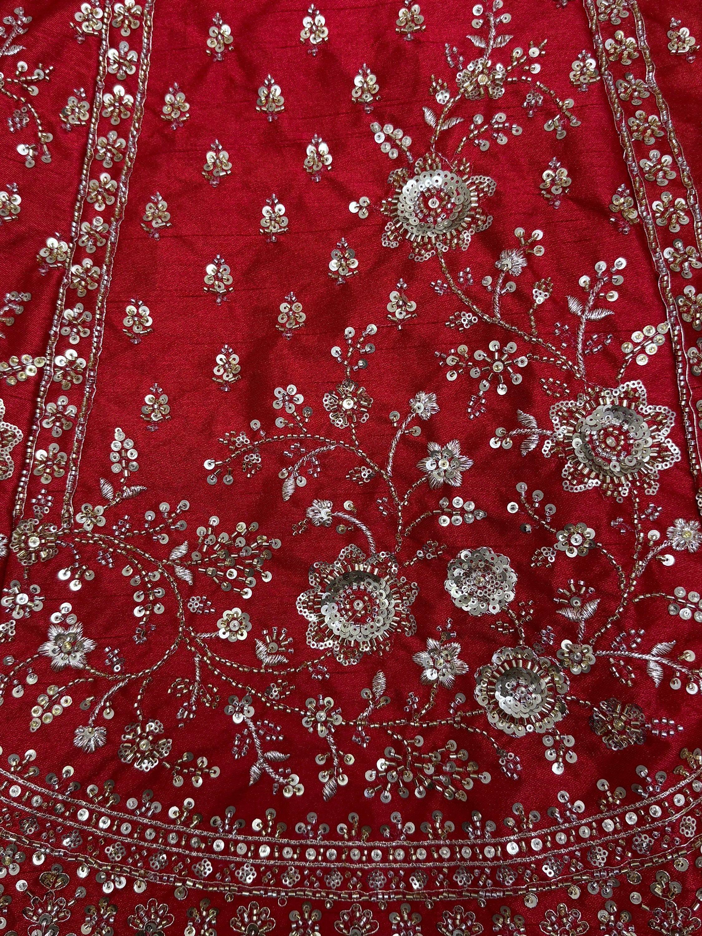Red ethnic wear with intricate silver sequin and bead floral embroidery, perfect for Indian celebrations.