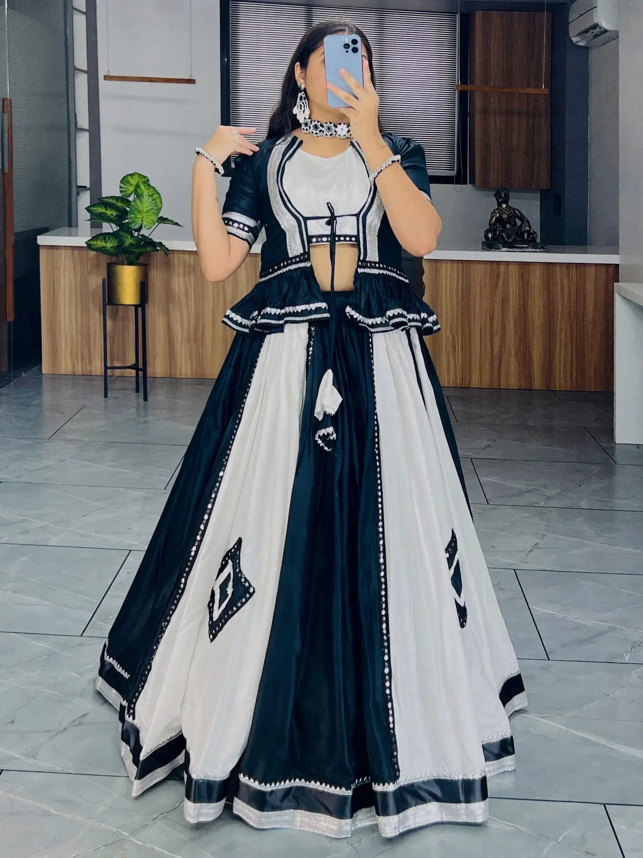 Black and white ethnic lehenga choli with ruffled blouse and geometric embroidery, perfect for festive occasions.