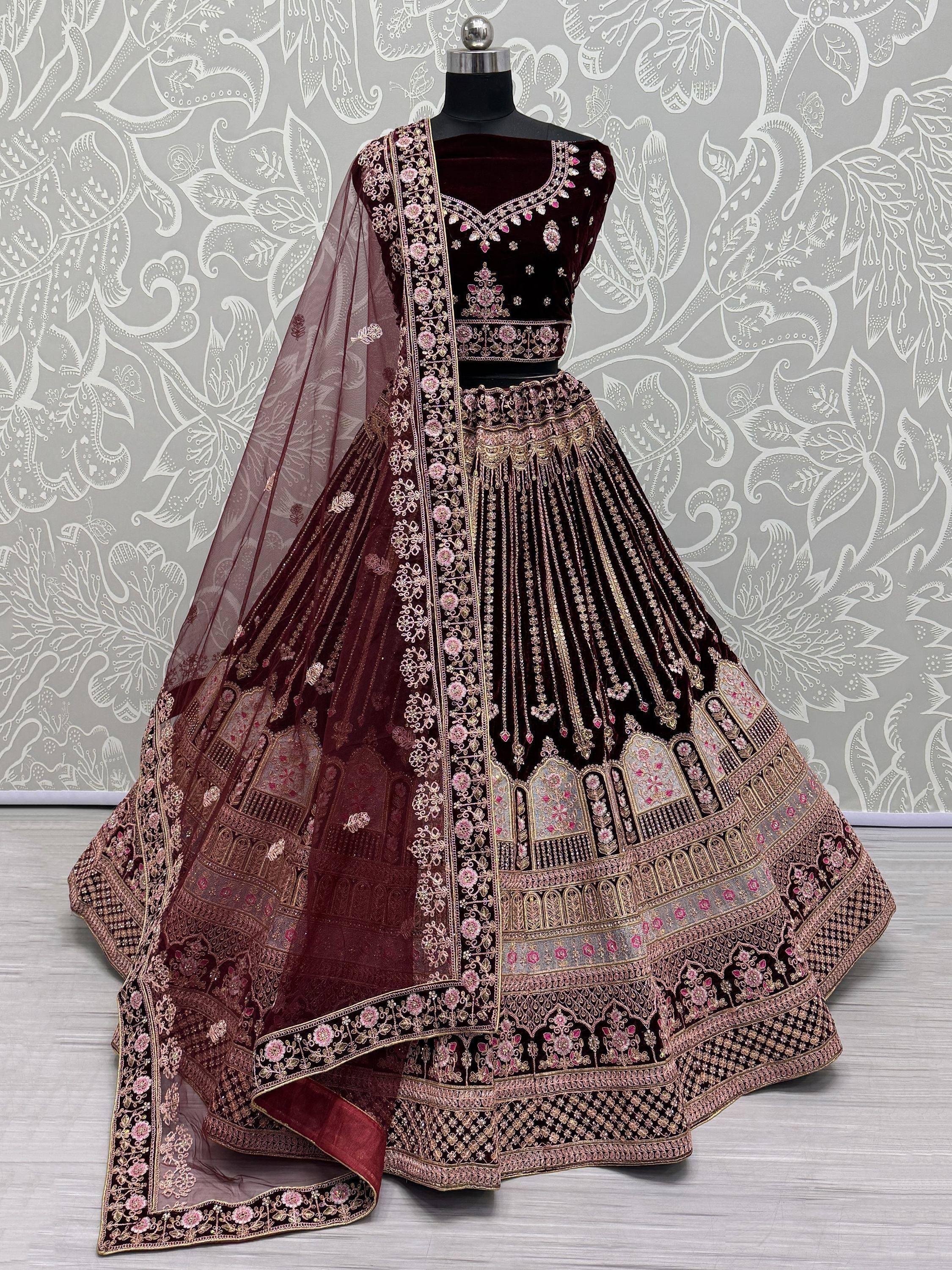 Elegant maroon velvet lehenga choli with intricate gold and pink embroidery, perfect for Indian ethnic wear.
