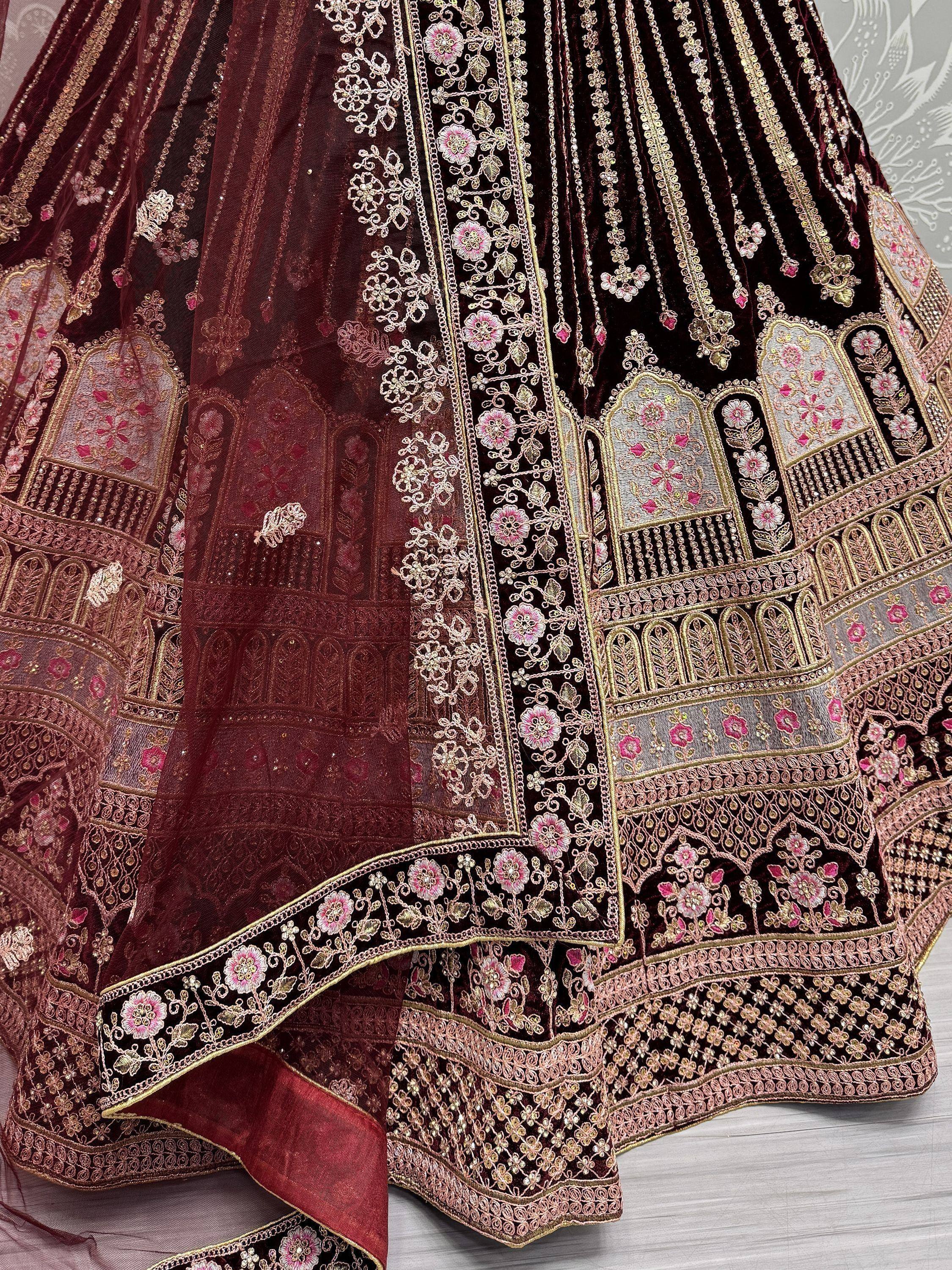 Maroon velvet lehenga with intricate gold and pink floral embroidery, perfect for Indian ethnic wear.