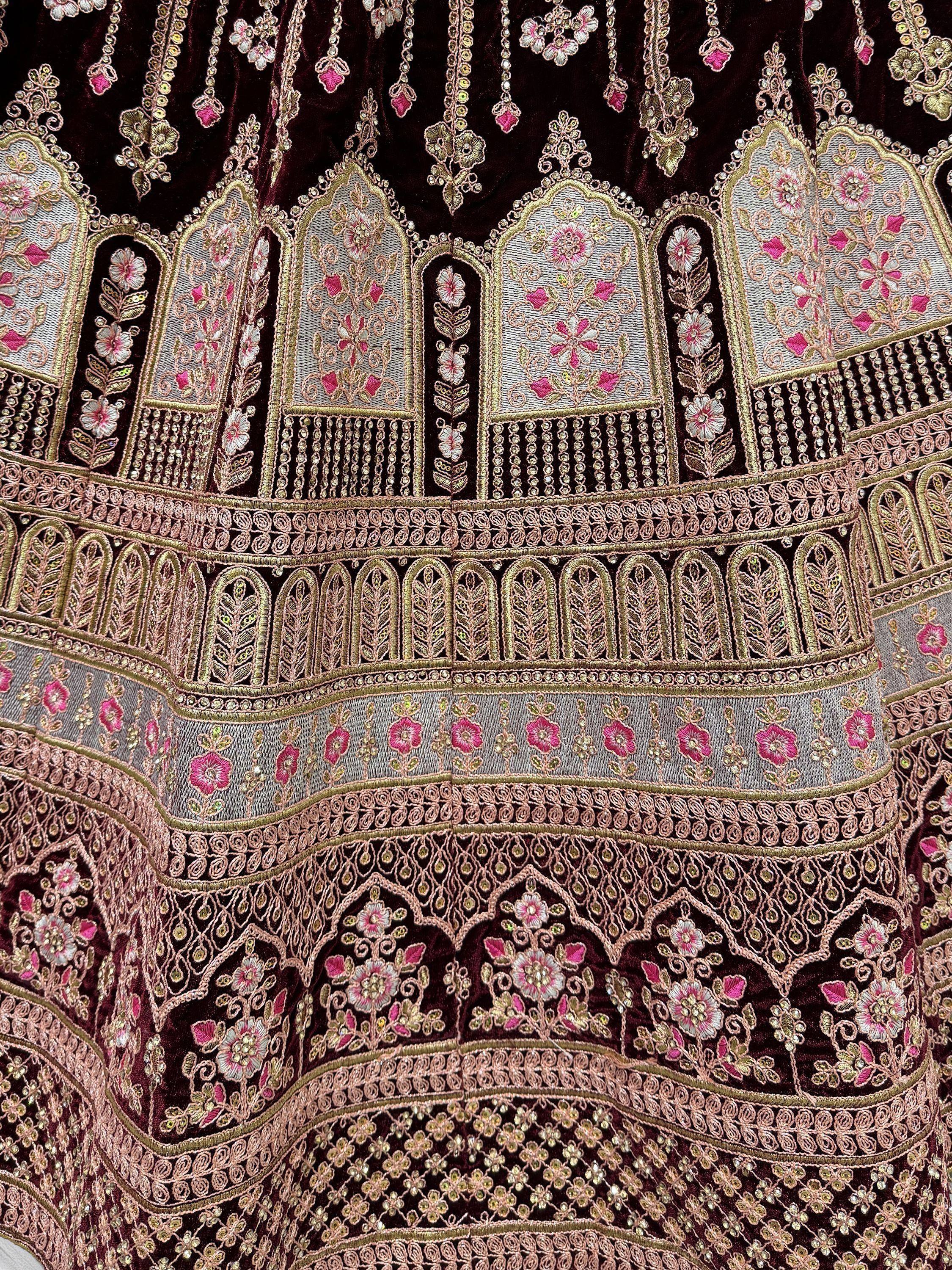 Elegant maroon velvet lehenga with intricate floral embroidery and gold detailing