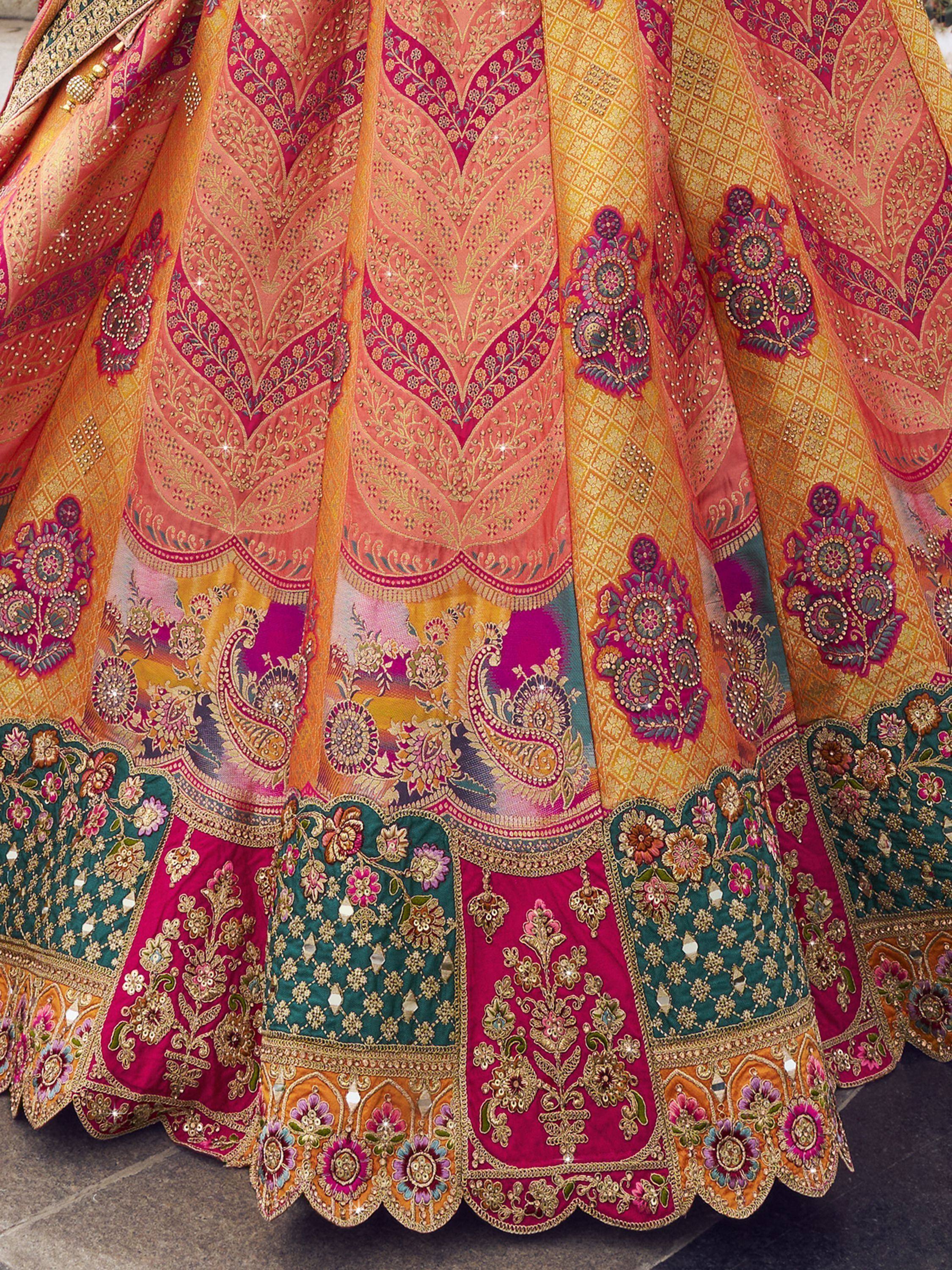 Designer lehenga choli with intricate gold embroidery, floral patterns, and vibrant pink, orange, green hues for Indian ethnic wear.