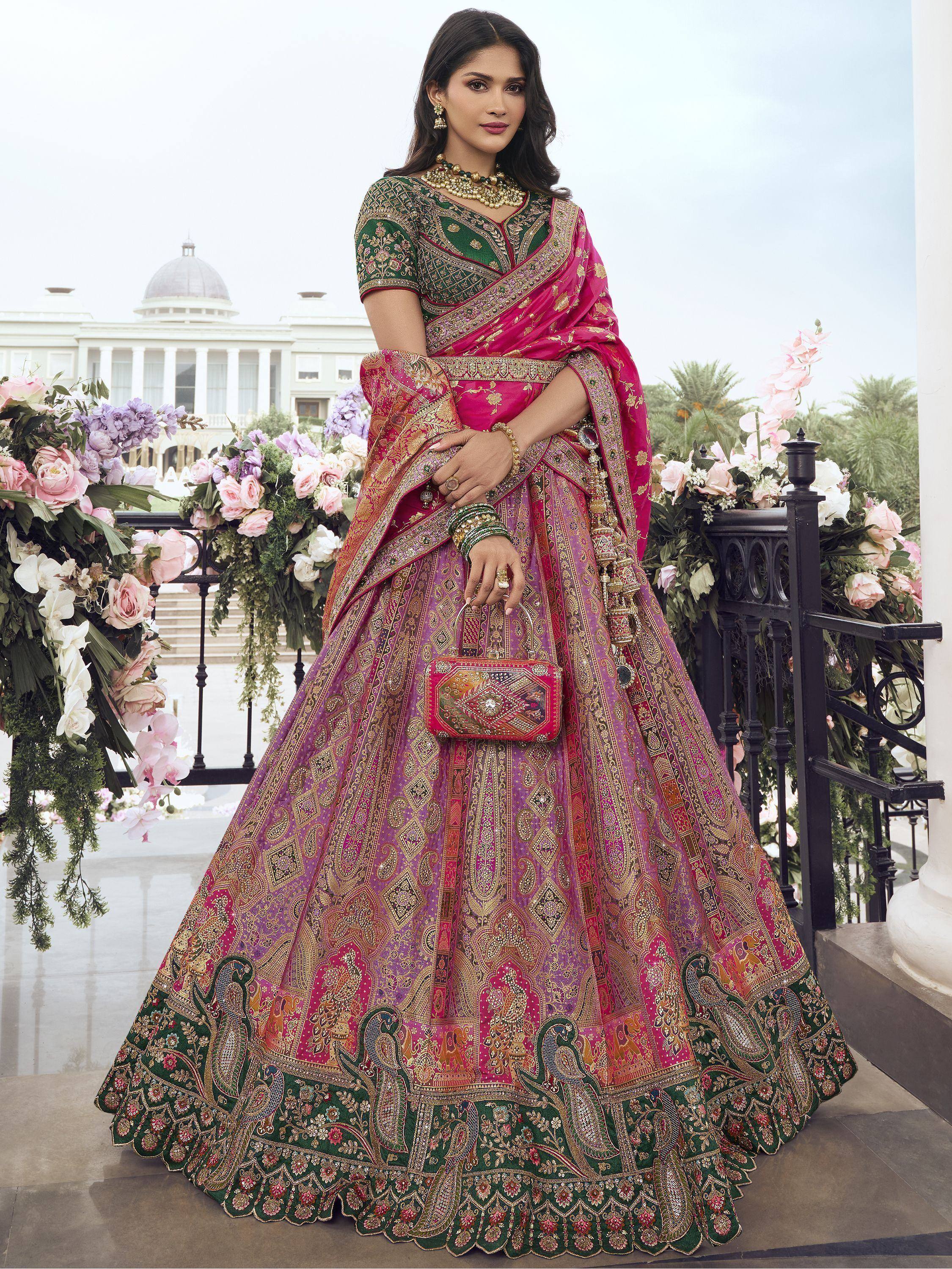 Woman in vibrant pink and green designer lehenga choli with intricate embroidery, perfect for Indian weddings and festive occasions.