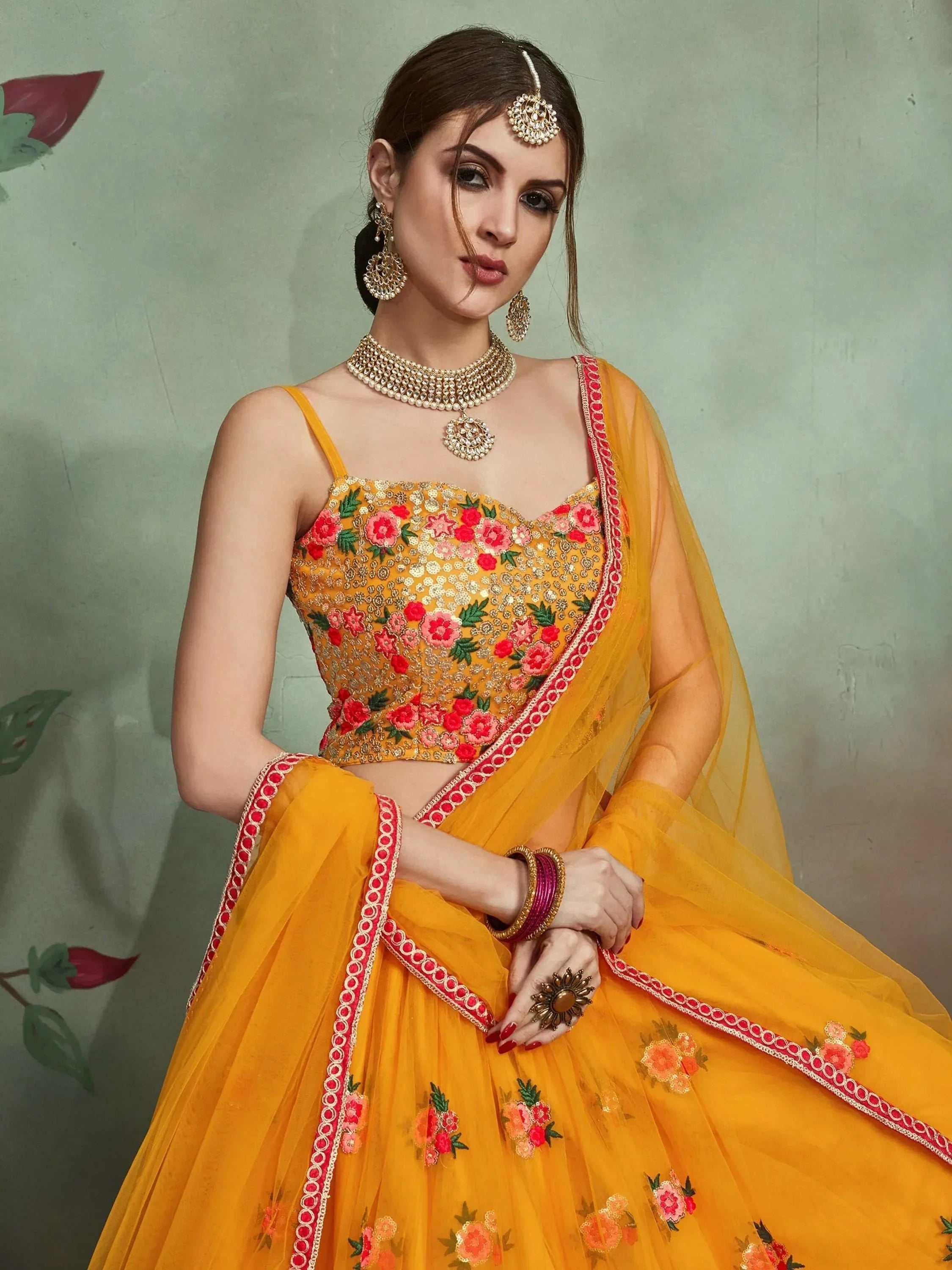 Yellow floral embroidered lehenga choli with red border, perfect for Indian weddings and festive occasions
