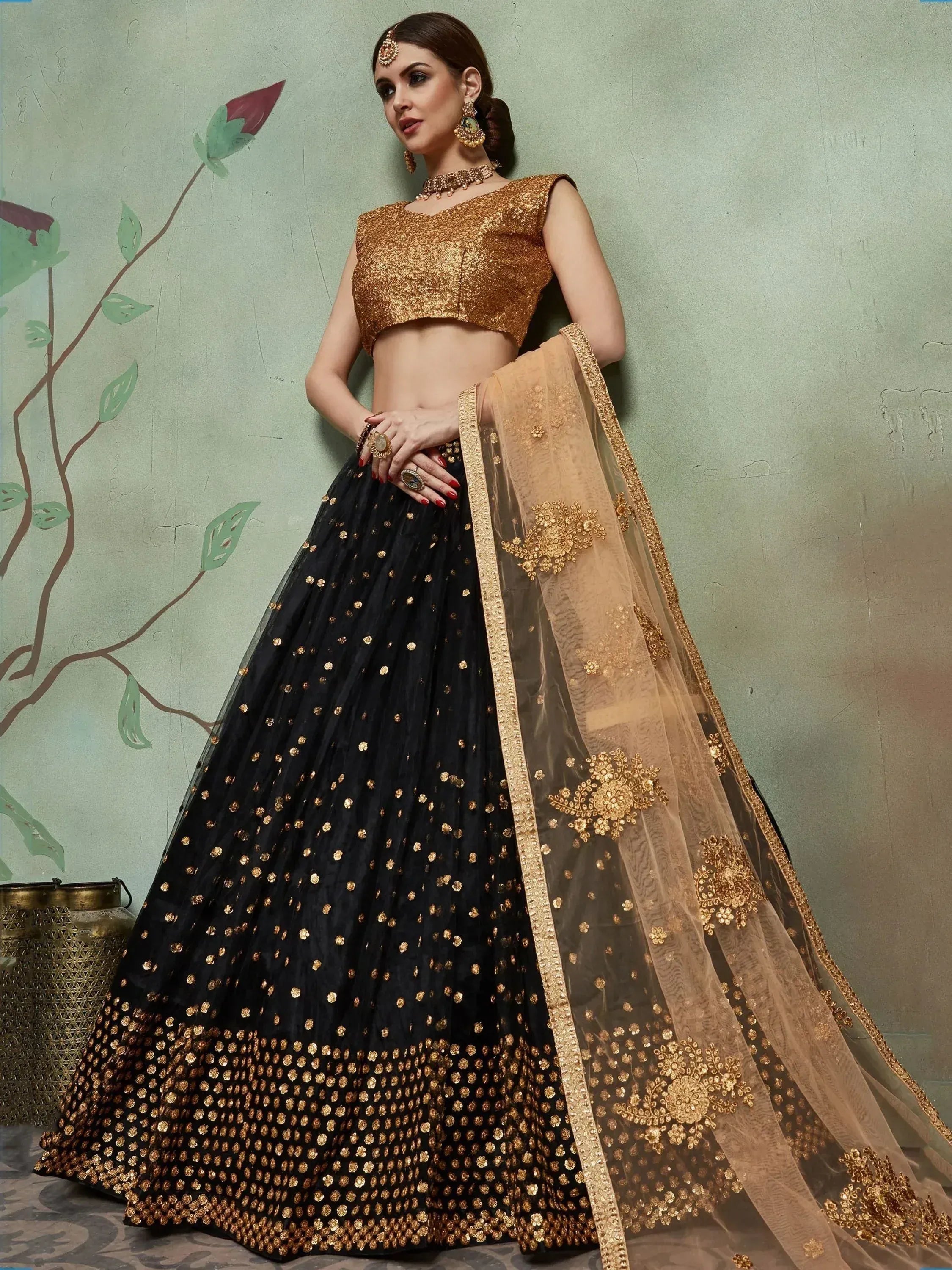 Black and gold embroidered lehenga choli with sheer dupatta, perfect for Indian weddings and festive occasions.