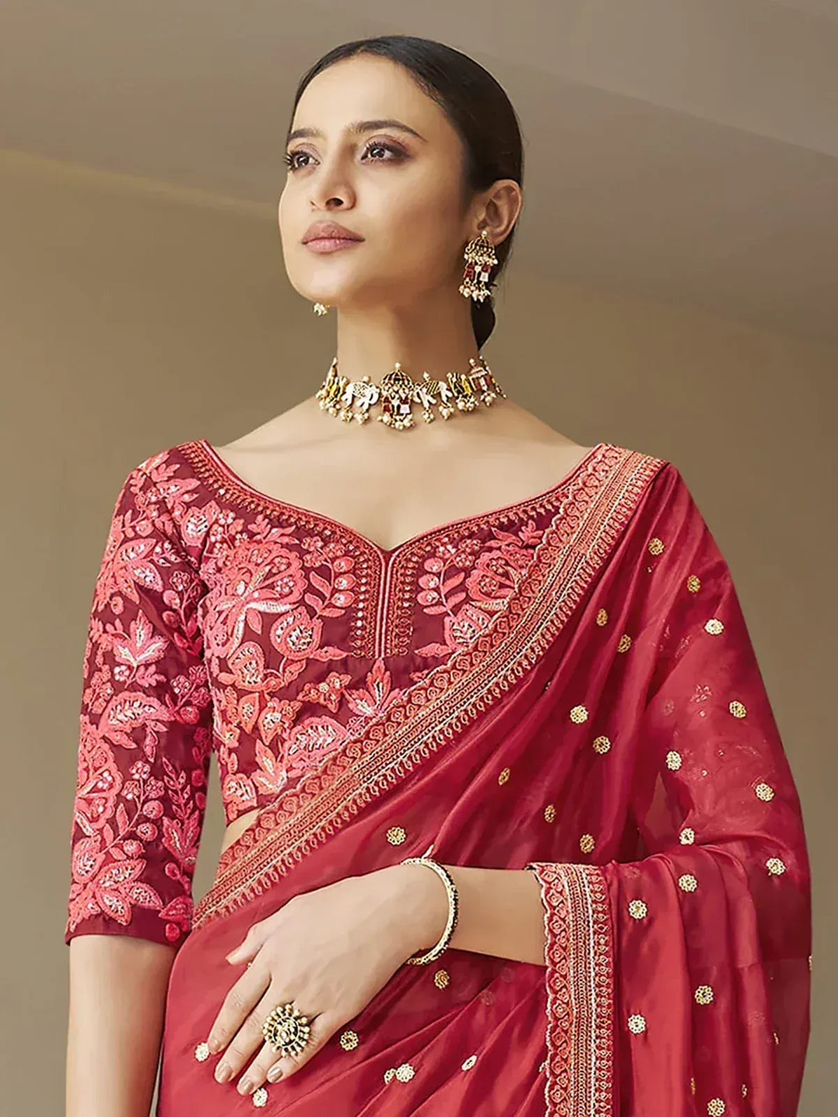 Elegant maroon saree with floral embroidery and gold detailing, paired with traditional jewelry for Indian ethnic wear