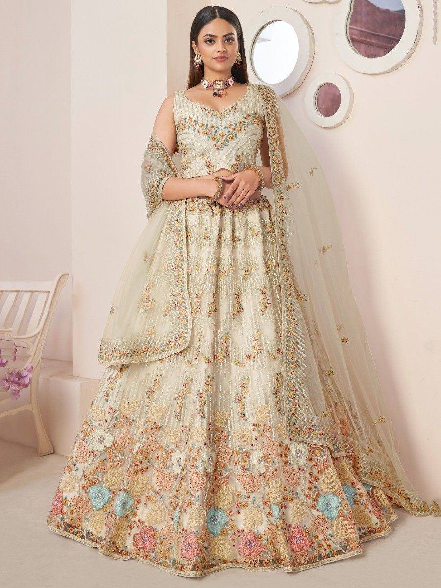Elegant cream lehenga choli with floral embroidery and sheer dupatta, perfect for Indian weddings and festivals.