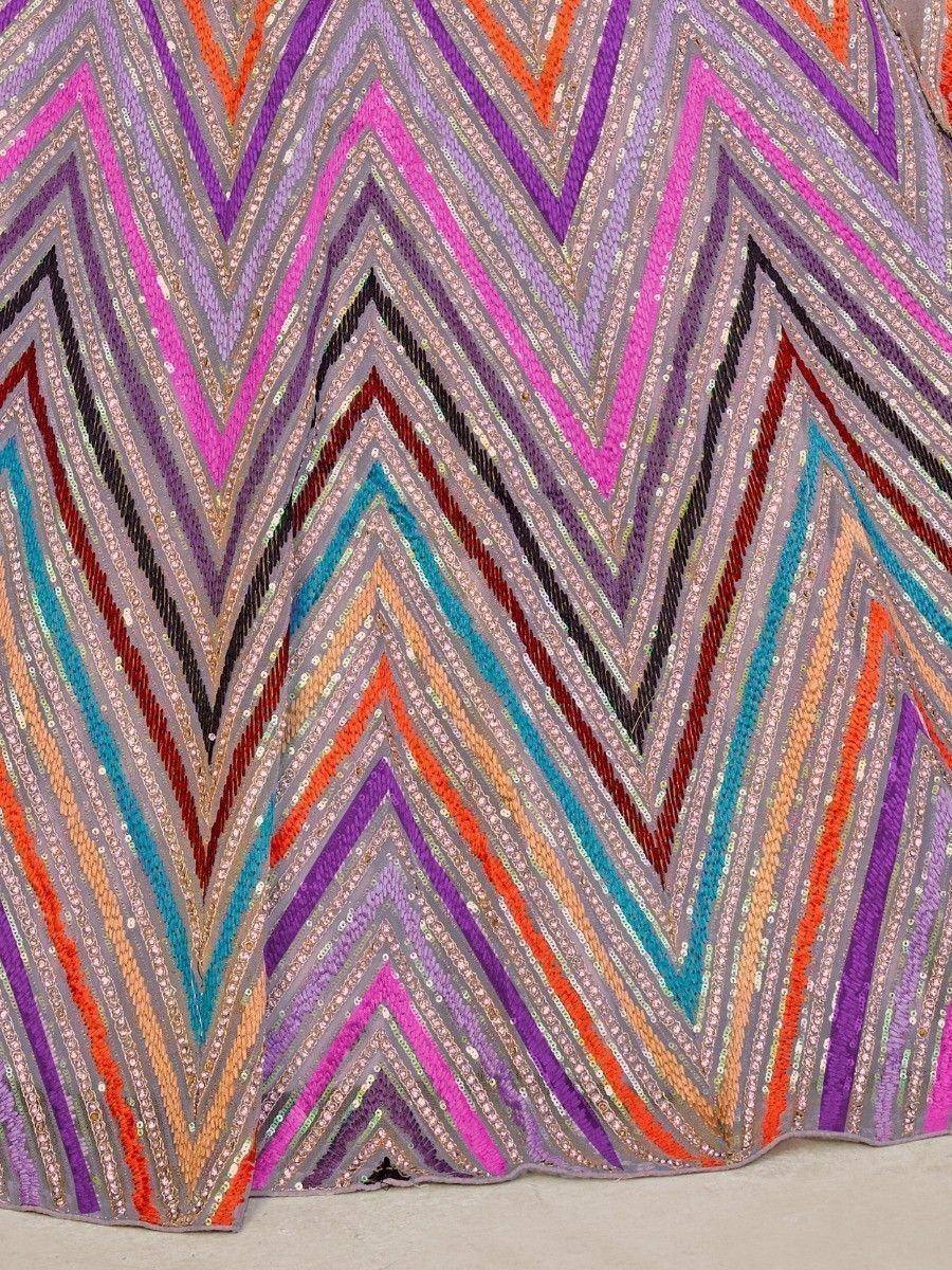 Vibrant zigzag sequin embroidery on ethnic gown fabric, featuring pink, purple, orange, and teal hues for festive wear.