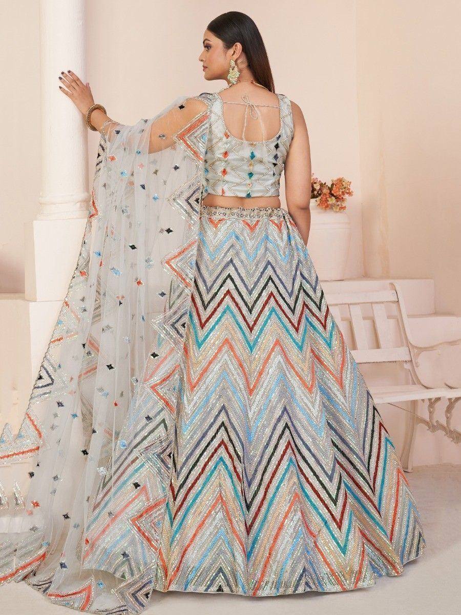 Designer lehenga choli with colorful zigzag embroidery and sheer dupatta, perfect for Indian ethnic occasions.