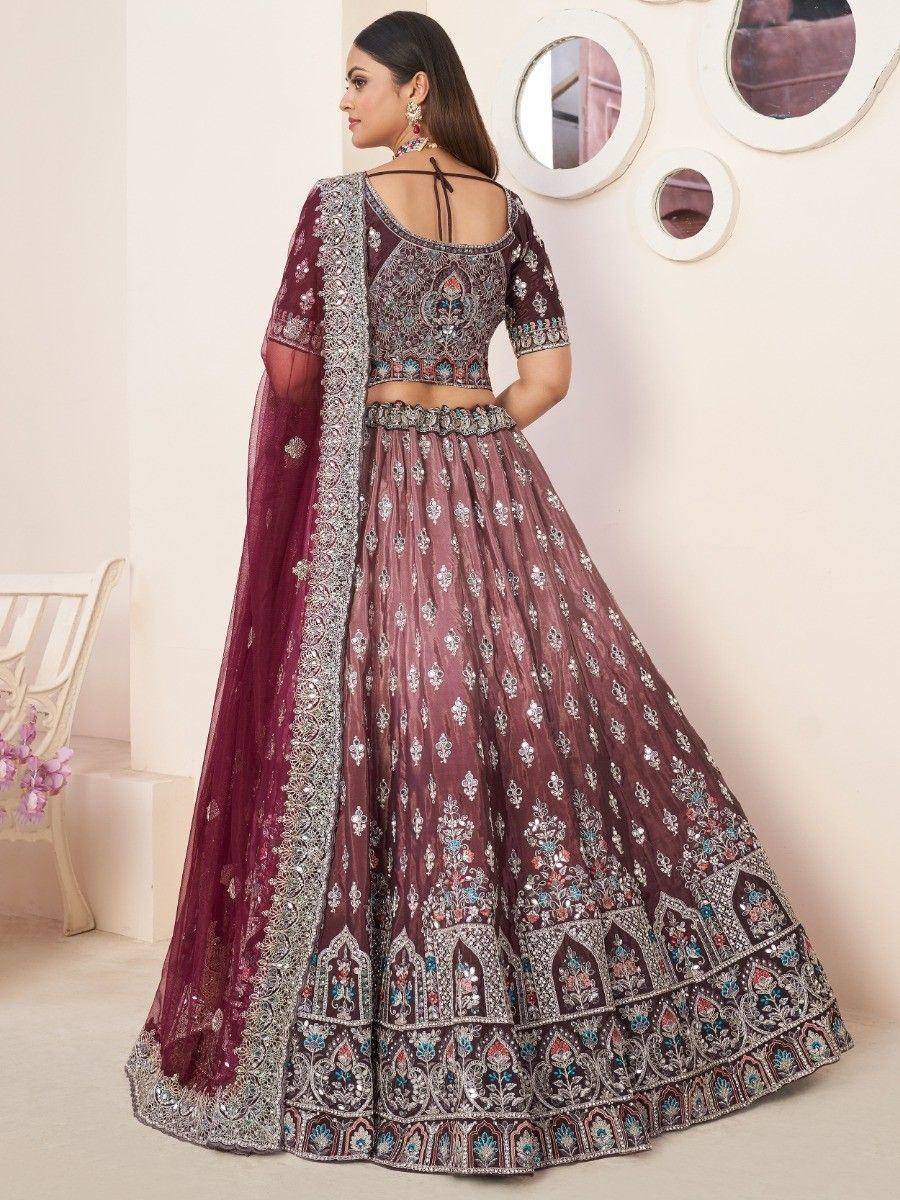 Maroon embroidered lehenga choli with heavy embellishments and sheer dupatta, perfect for Indian weddings and festive occasions.