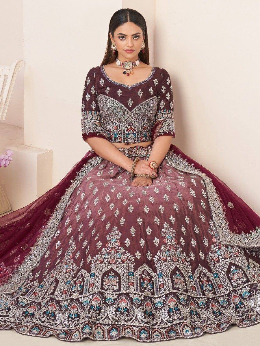 Maroon designer lehenga choli with heavy embroidery and mirror work, perfect for Indian weddings and festivals.