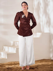 Woman in a brown designer top with floral brooch and white wide-leg pants, Ethnic Plus fashion