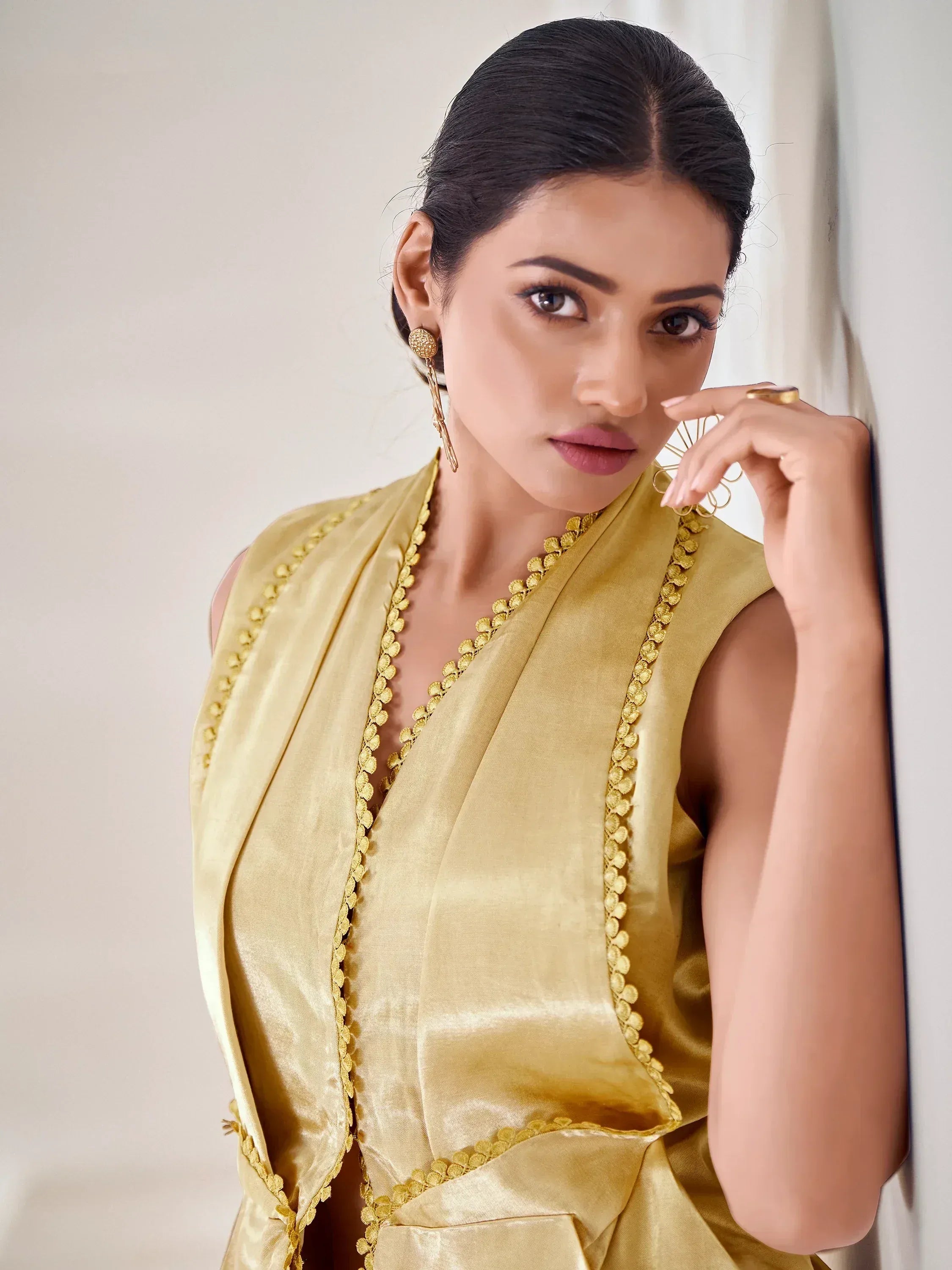 Elegant woman in golden sleeveless ethnic gown with scalloped detailing, perfect for Indian occasions.