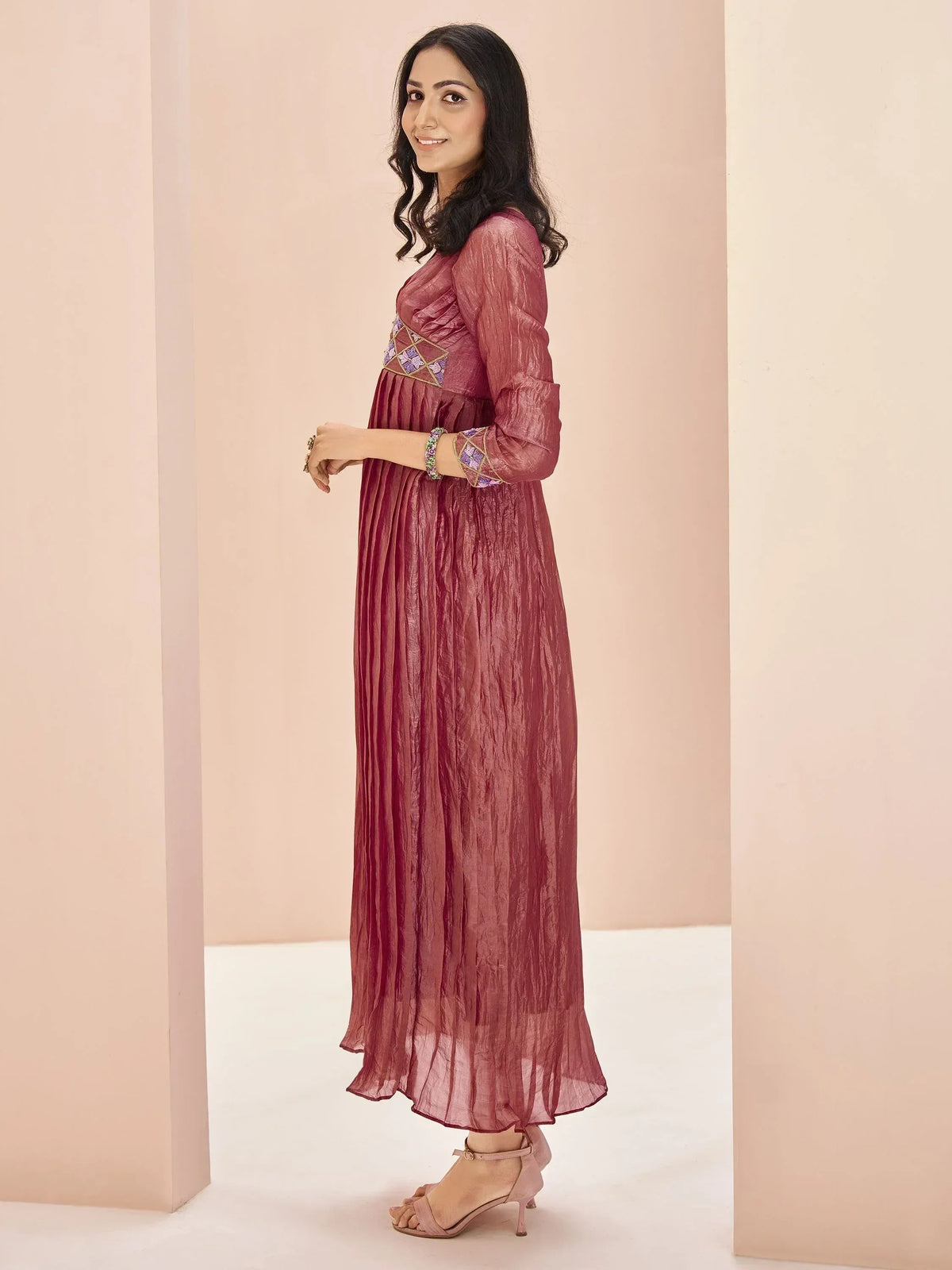 Woman in maroon ethnic gown with embroidered detailing, perfect for Indian occasions and festive wear.