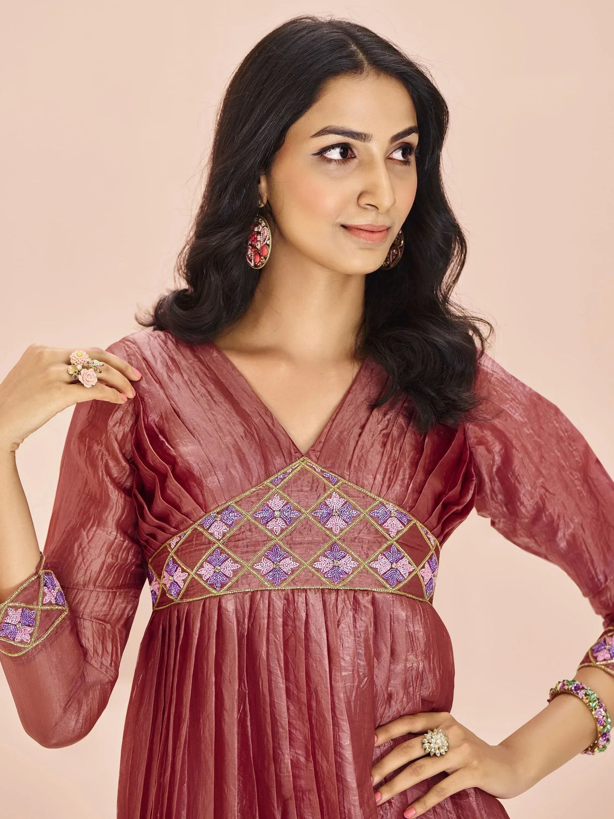 Woman in maroon ethnic gown with floral embroidery, perfect for Indian occasions and festive wear.