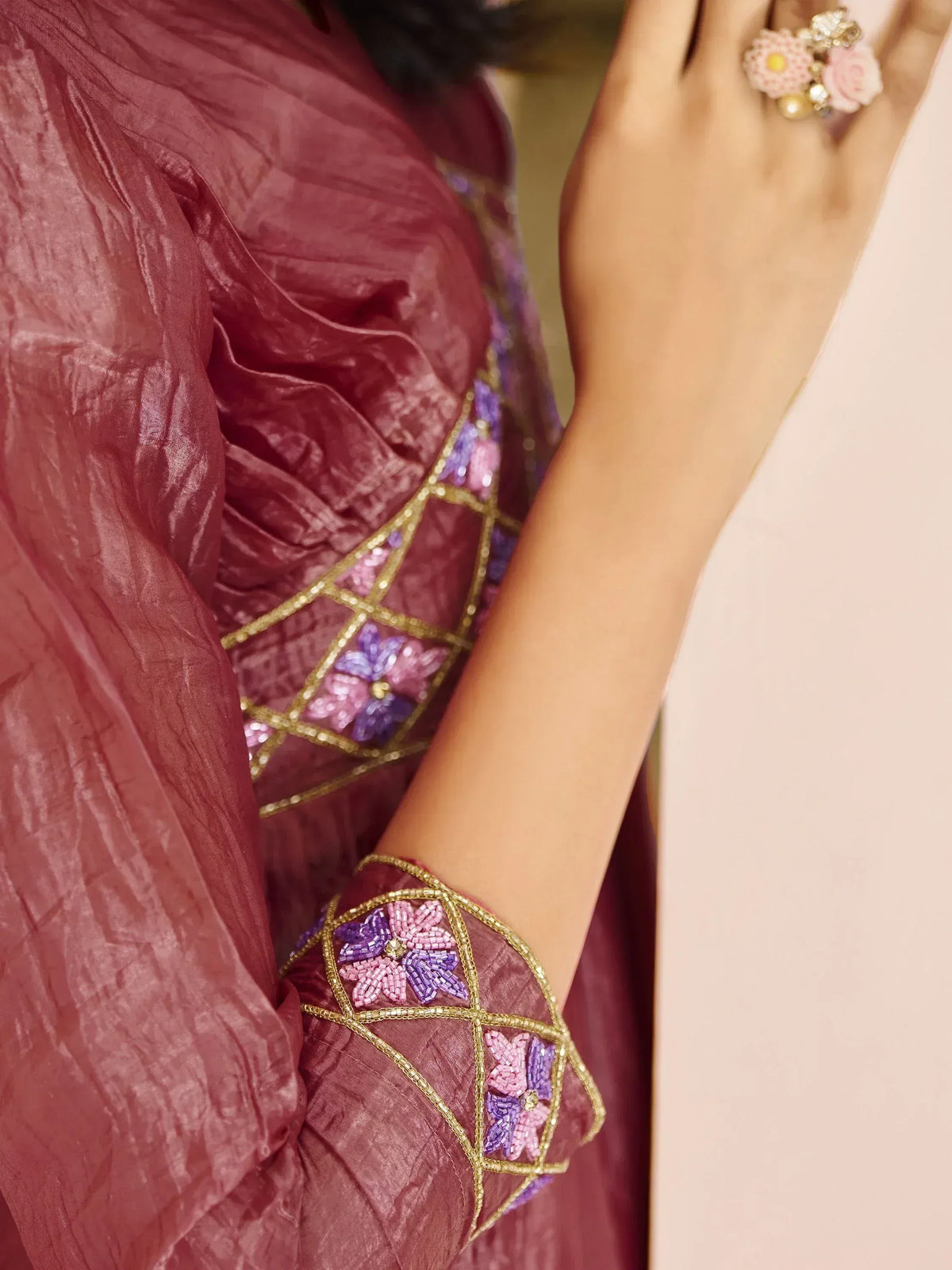 Maroon ethnic gown with floral beadwork and gold trim, perfect for Indian occasions
