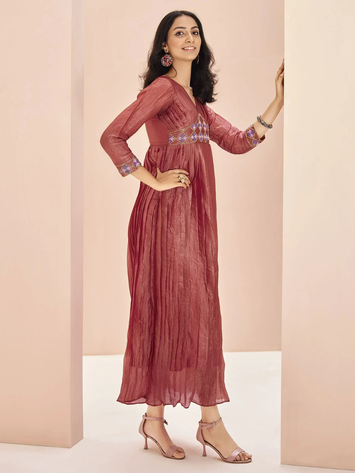 Woman in dusty rose ethnic gown with purple embroidery, perfect for Indian occasions and festive wear.