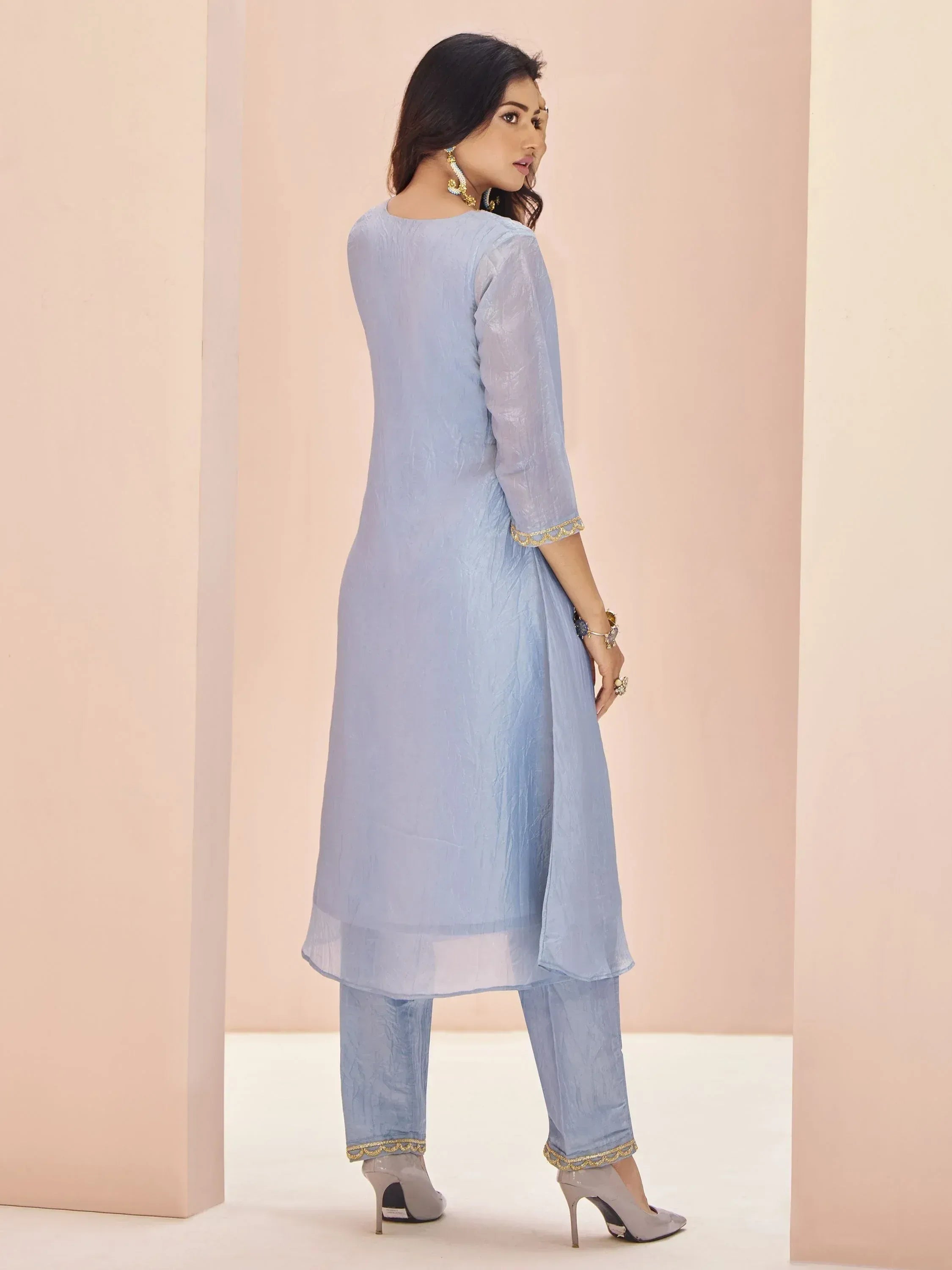 Light blue ethnic kurta with gold trim, matching pants, and heels for women's Indian wear