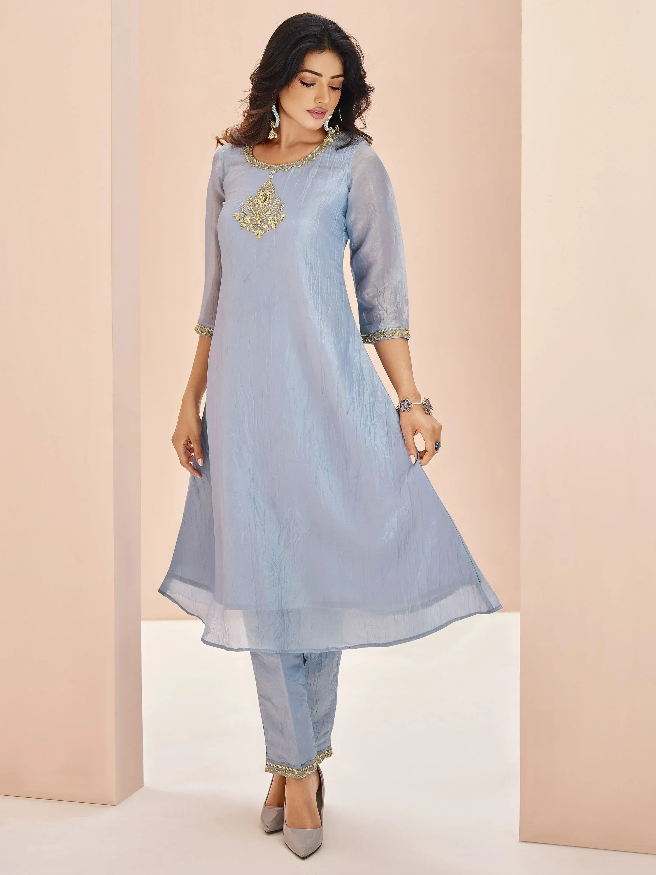 Woman wearing a light blue embroidered salwar kameez with three-quarter sleeves