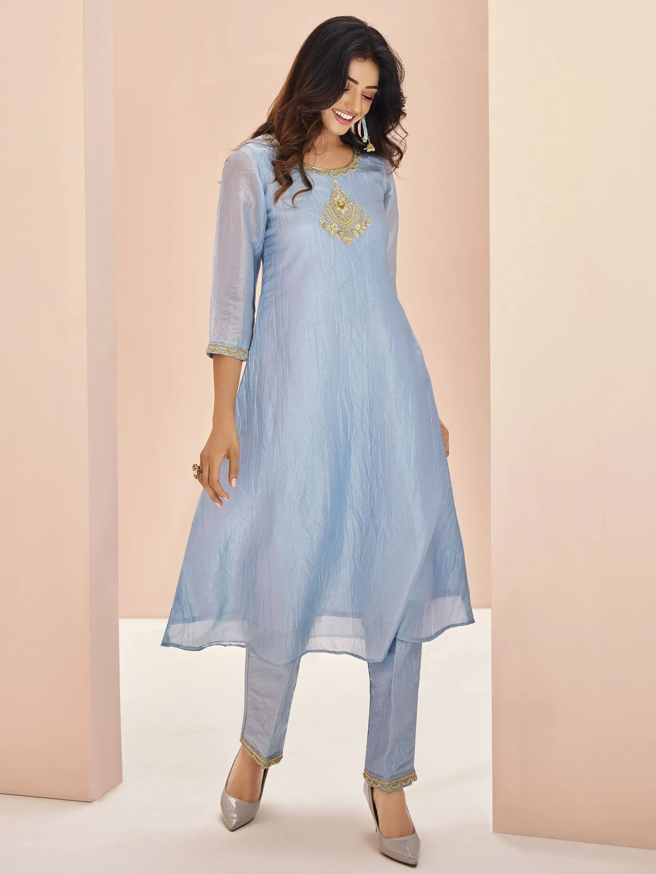 Woman in light blue embroidered kurta and straight pants, showcasing ethnic Indian salwar suit
