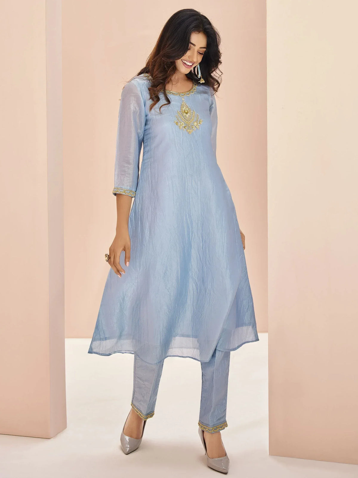 Light blue ethnic kurta with gold embroidery, paired with matching pants and heels for festive wear