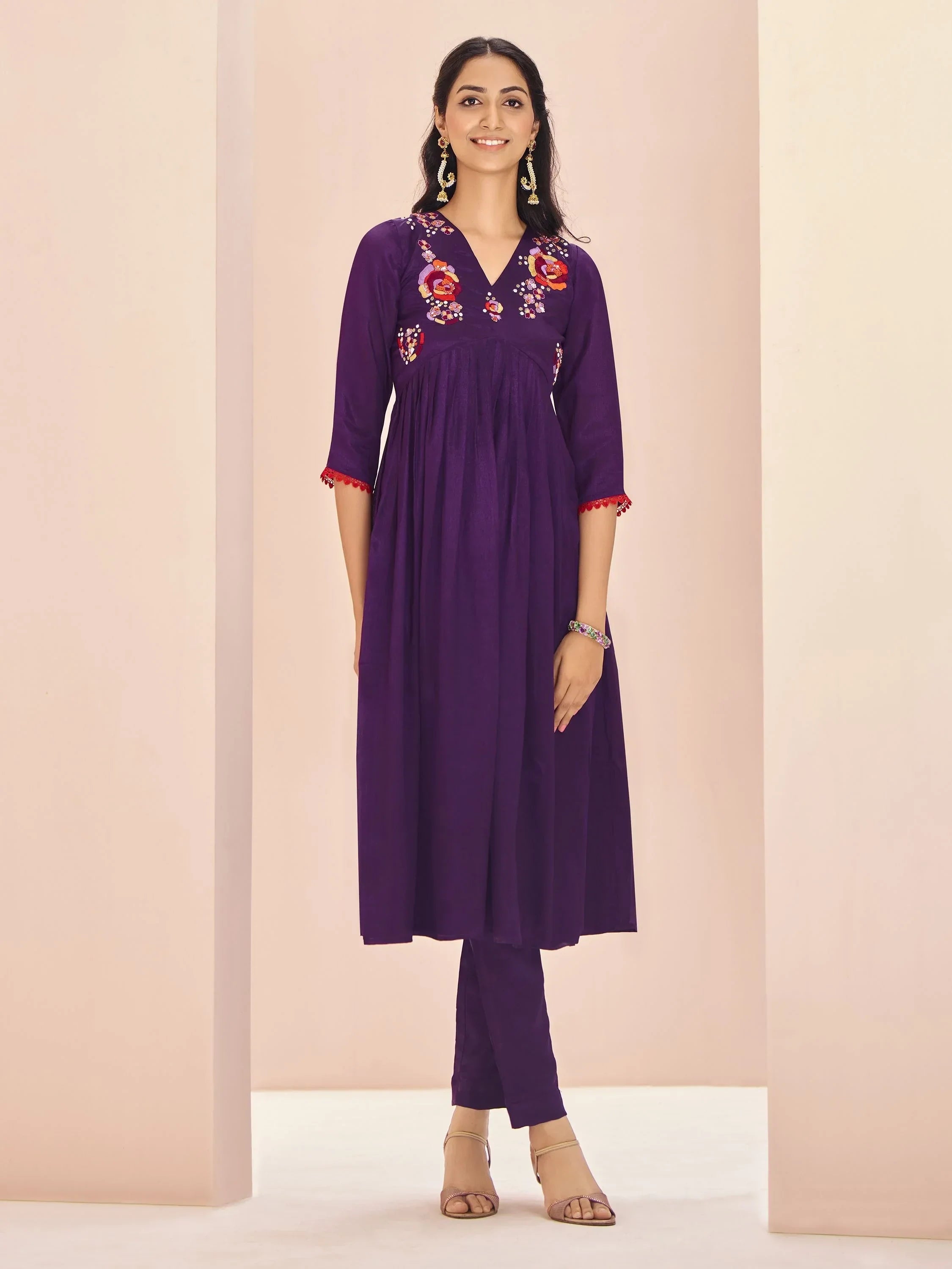 Woman wearing purple kurti with floral embroidery and matching pants, Indian ethnic wear