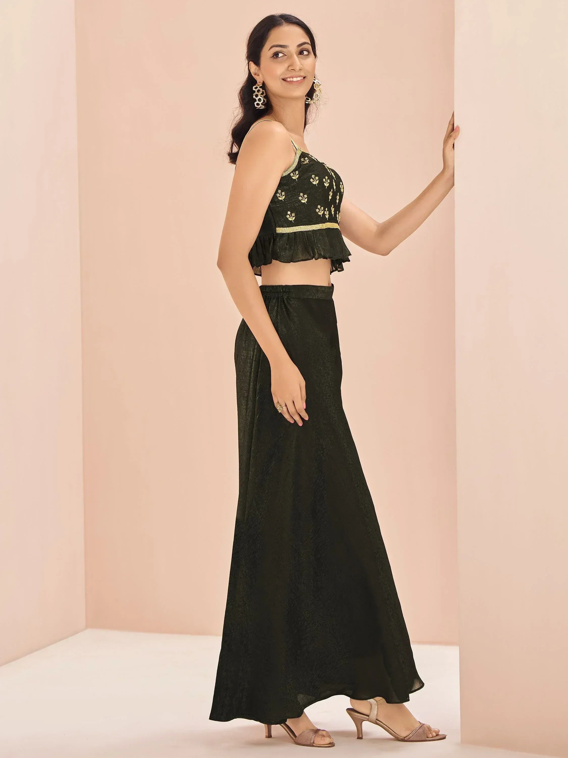 Elegant black ethnic gown with gold embroidery and ruffled top, perfect for Indian festive occasions.