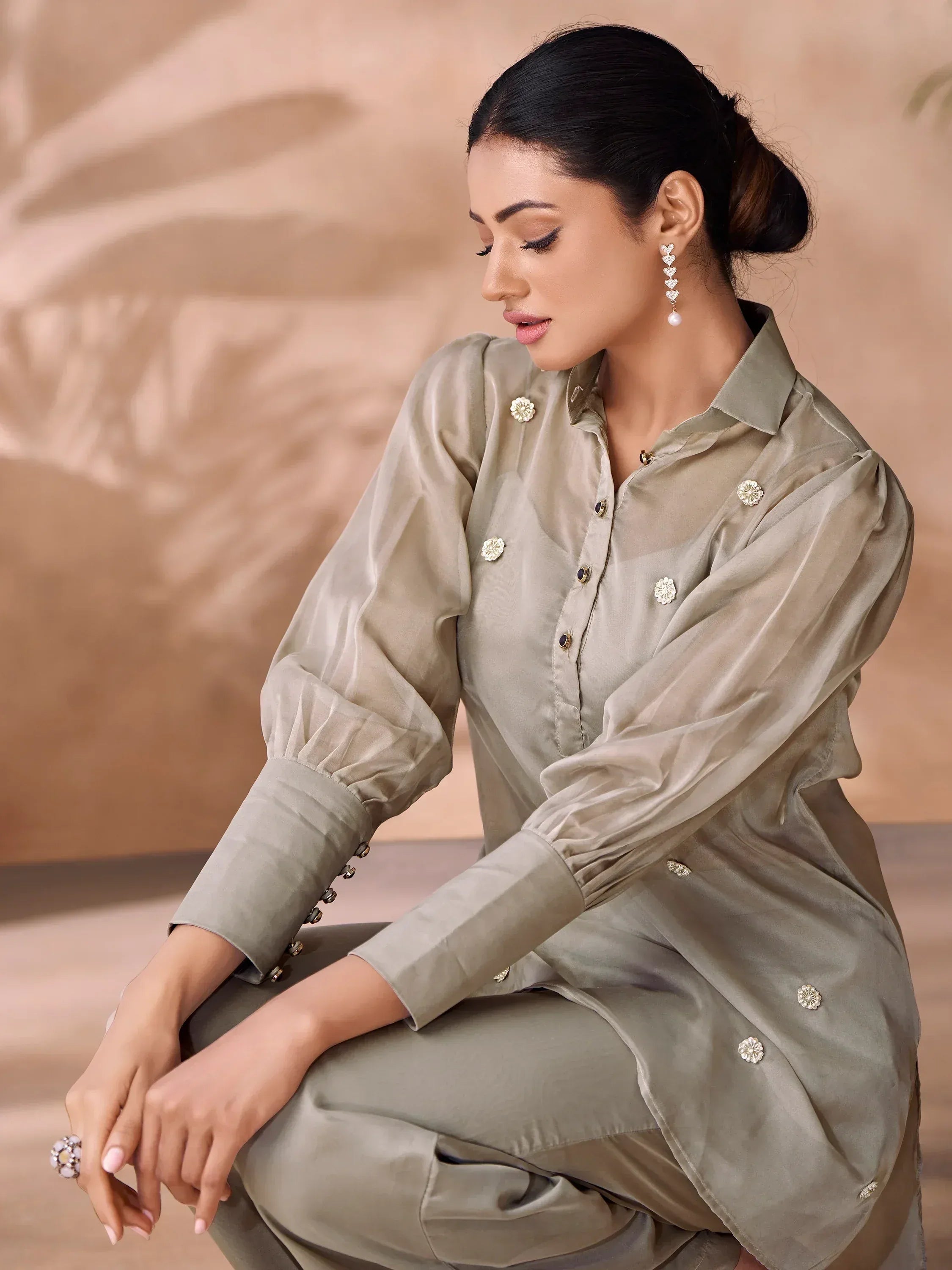 Stylish olive green ethnic kurti with floral embellishments and puff sleeves, paired with matching pants for modern Indian wear.